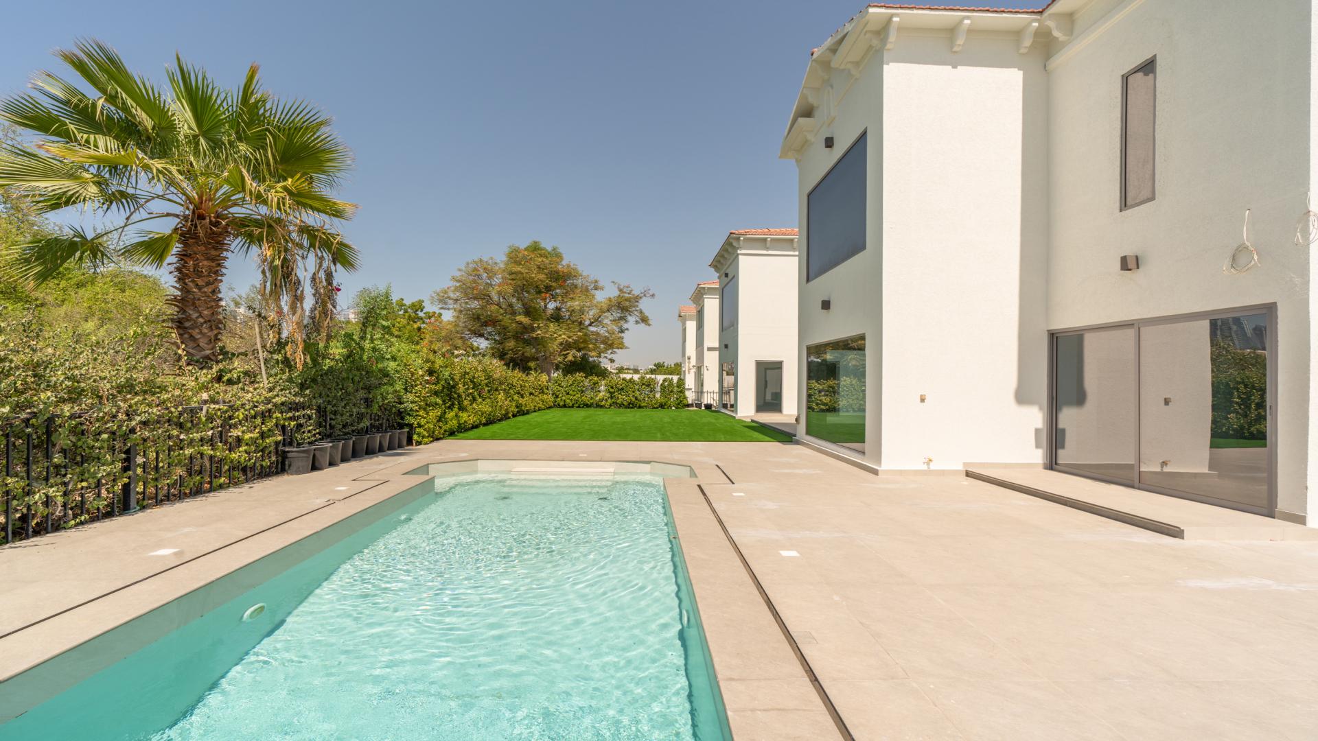 "Elegant 6-bed villa exterior with lush lawn in European Clusters, Jumeirah Islands.",Outdoor pool and patio of luxury villa in European Clusters, Jumeirah Islands