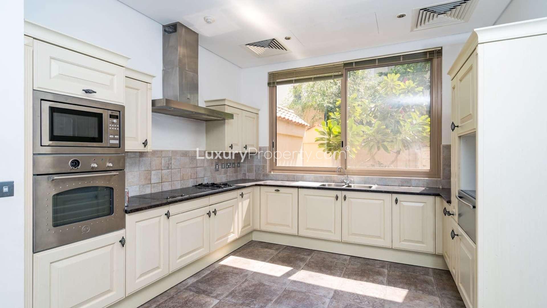 Modern kitchen in 6-bedroom Al Barari villa for rent, featuring built-in appliances and spacious layout