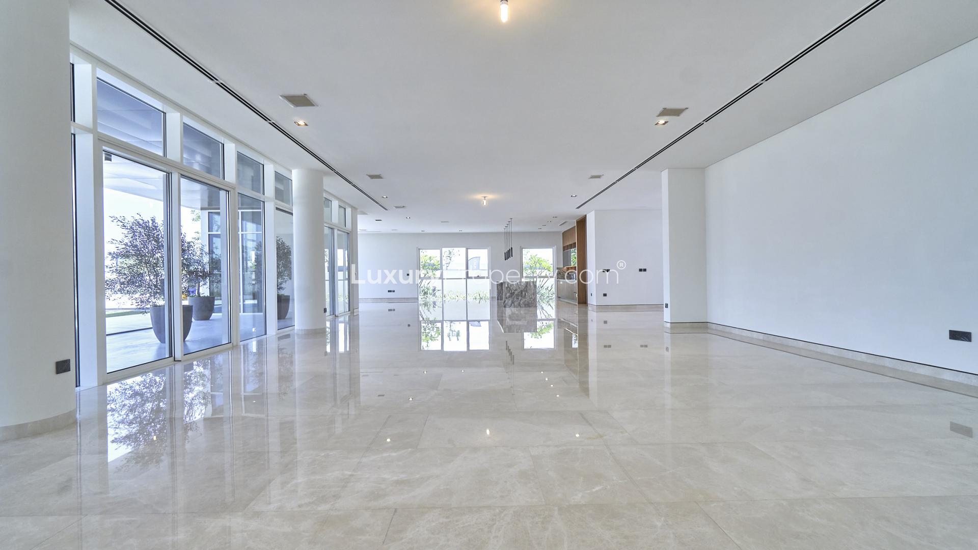 Modern kitchen in brand new Dubai Hills Estate villa, featuring sleek wooden cabinetry and island