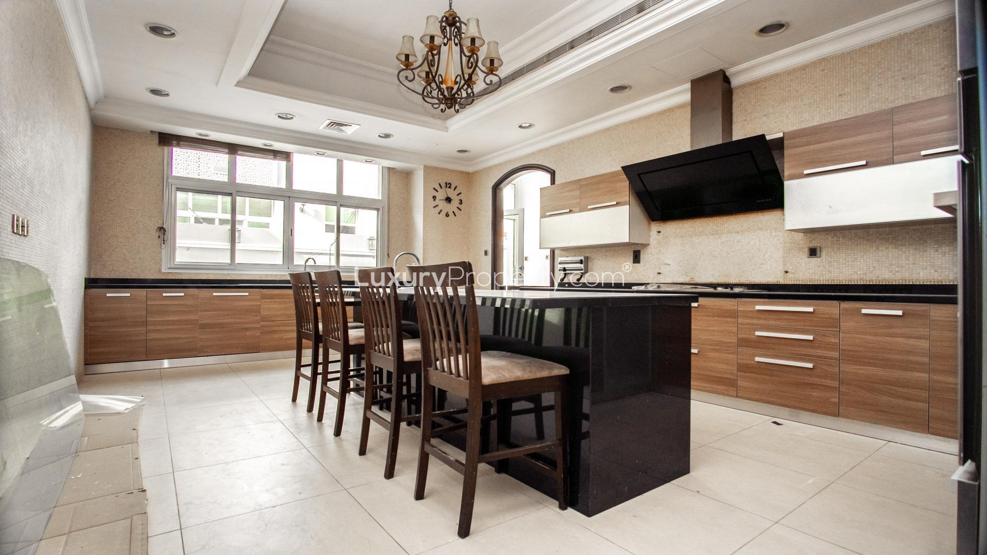 "Charming balcony view in Jumeirah 3 villa for rent, featuring outdoor seating area.",Luxurious modern kitchen in 6-bedroom Jumeirah villa, featuring island and elegant cabinetry