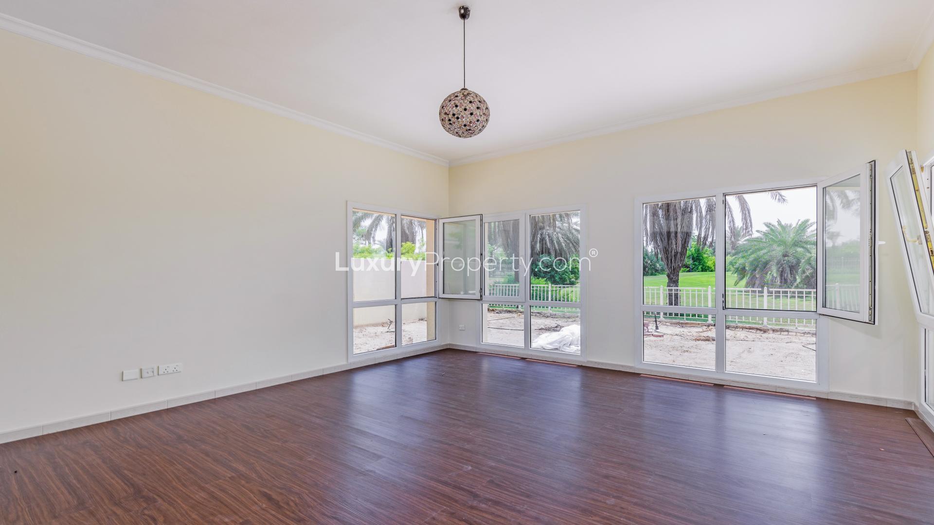 "Villa with scenic lake and golf course views in Meadows 3 community for rent.",Spacious villa room with large windows, overlooking lush greenery in Meadows 3 community