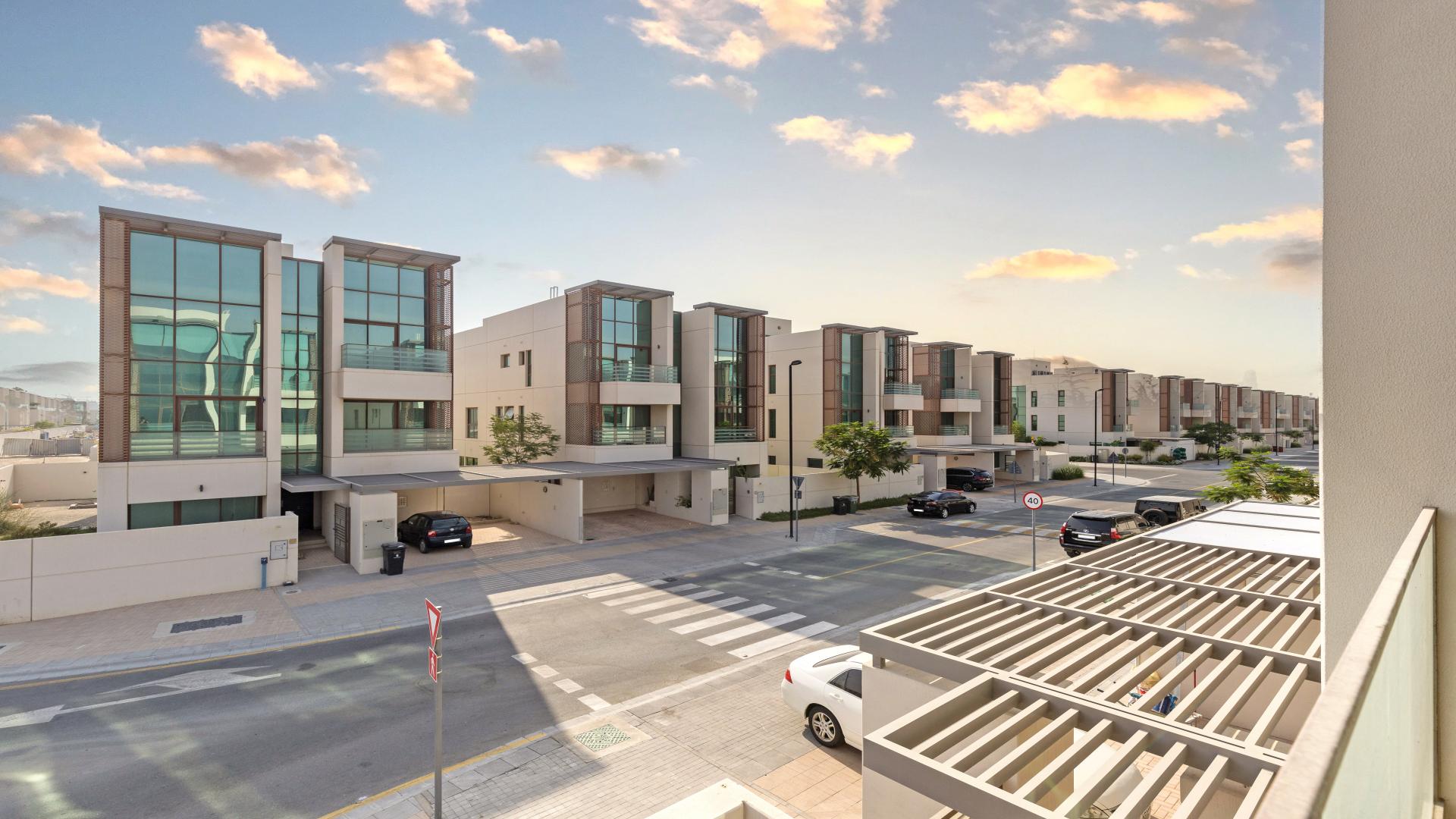 Spacious living area in brand new Meydan villa for rent, featuring large windows and staircase