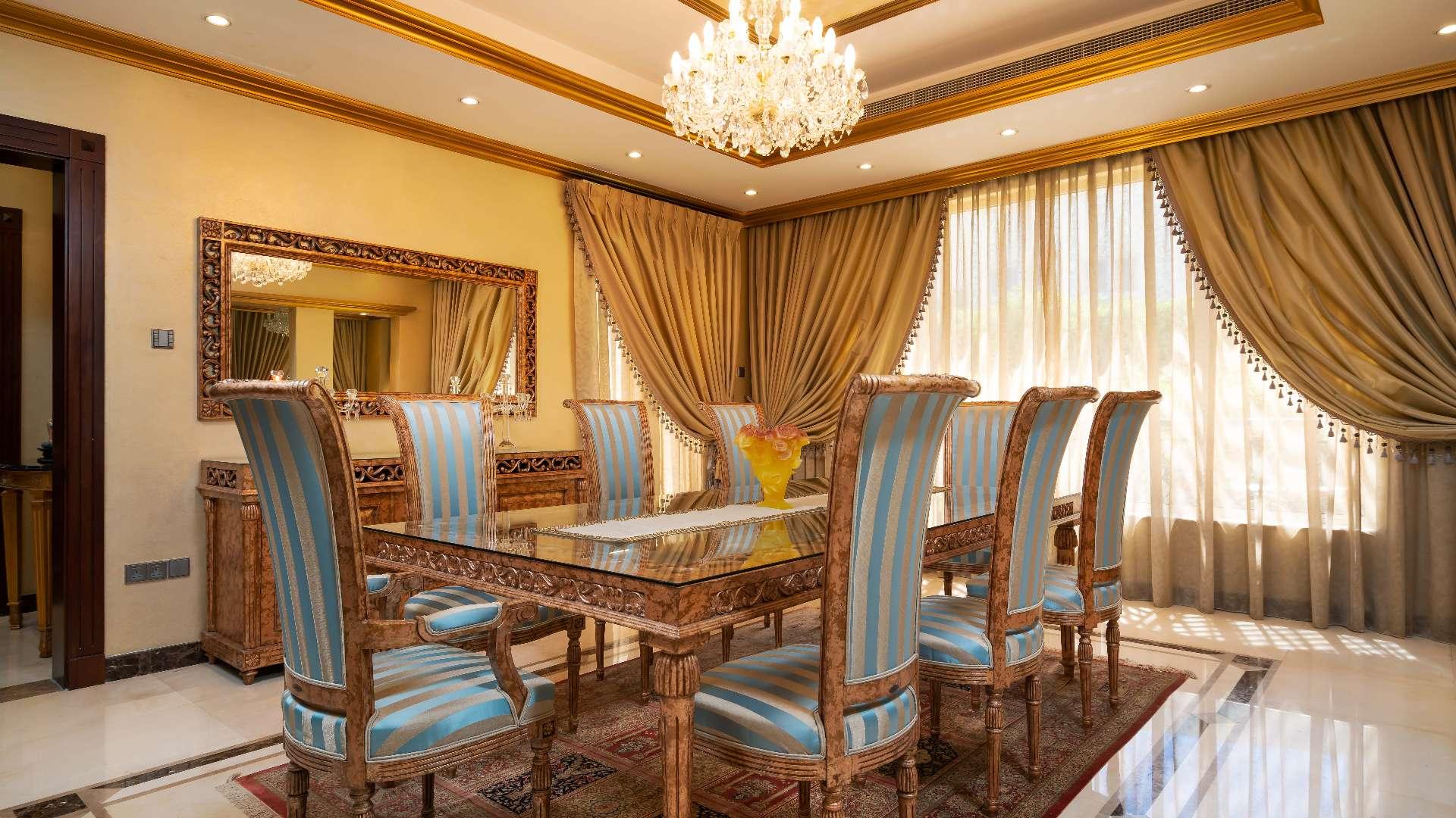 Luxurious villa entrance with ornate staircase and chandelier in Emirates Hills, Sector R