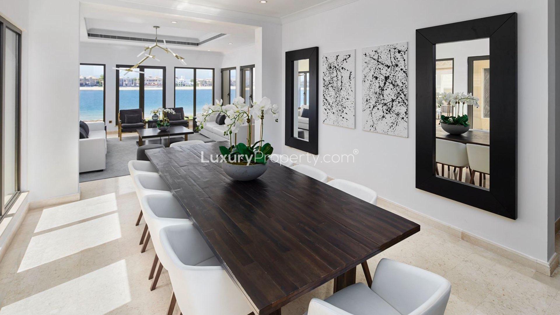 "Spacious terrace with wicker seating and ocean views at Palm Jumeirah villa for rent.",Dining area with elegant decor and sea views in Palm Jumeirah villa for rent