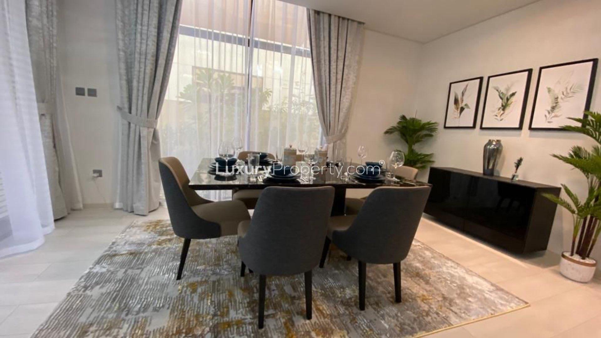 Dining area in fully furnished villa, Damac Hills, with park views and elegant decor