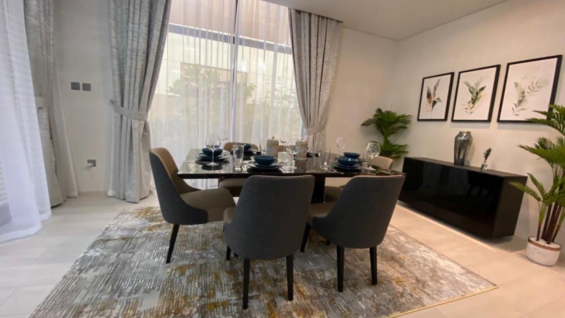 Dining area in fully furnished villa, Damac Hills, with park views and elegant decor