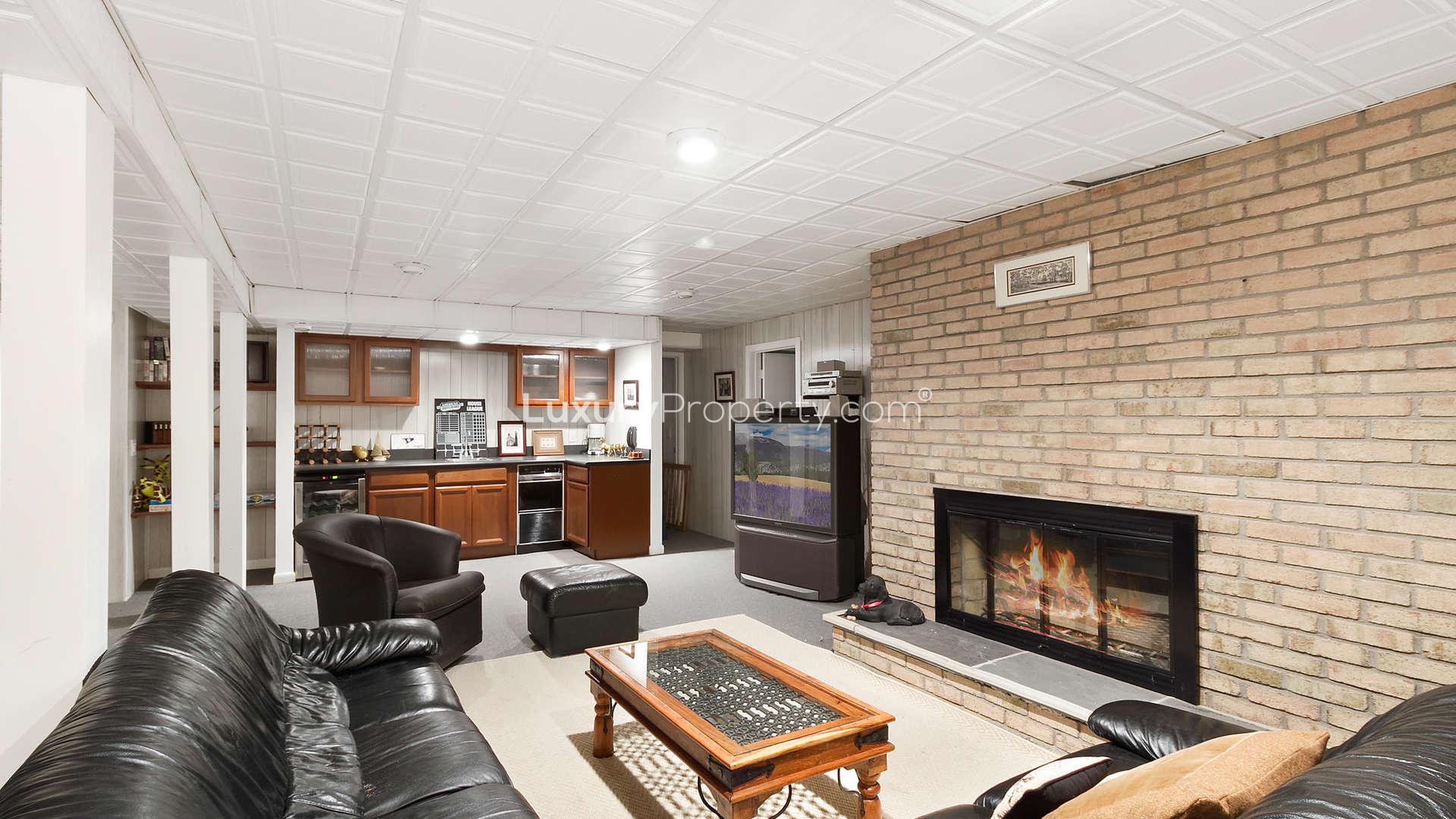 Spacious living room with stone fireplace in 6-bedroom Hamptons villa for sale