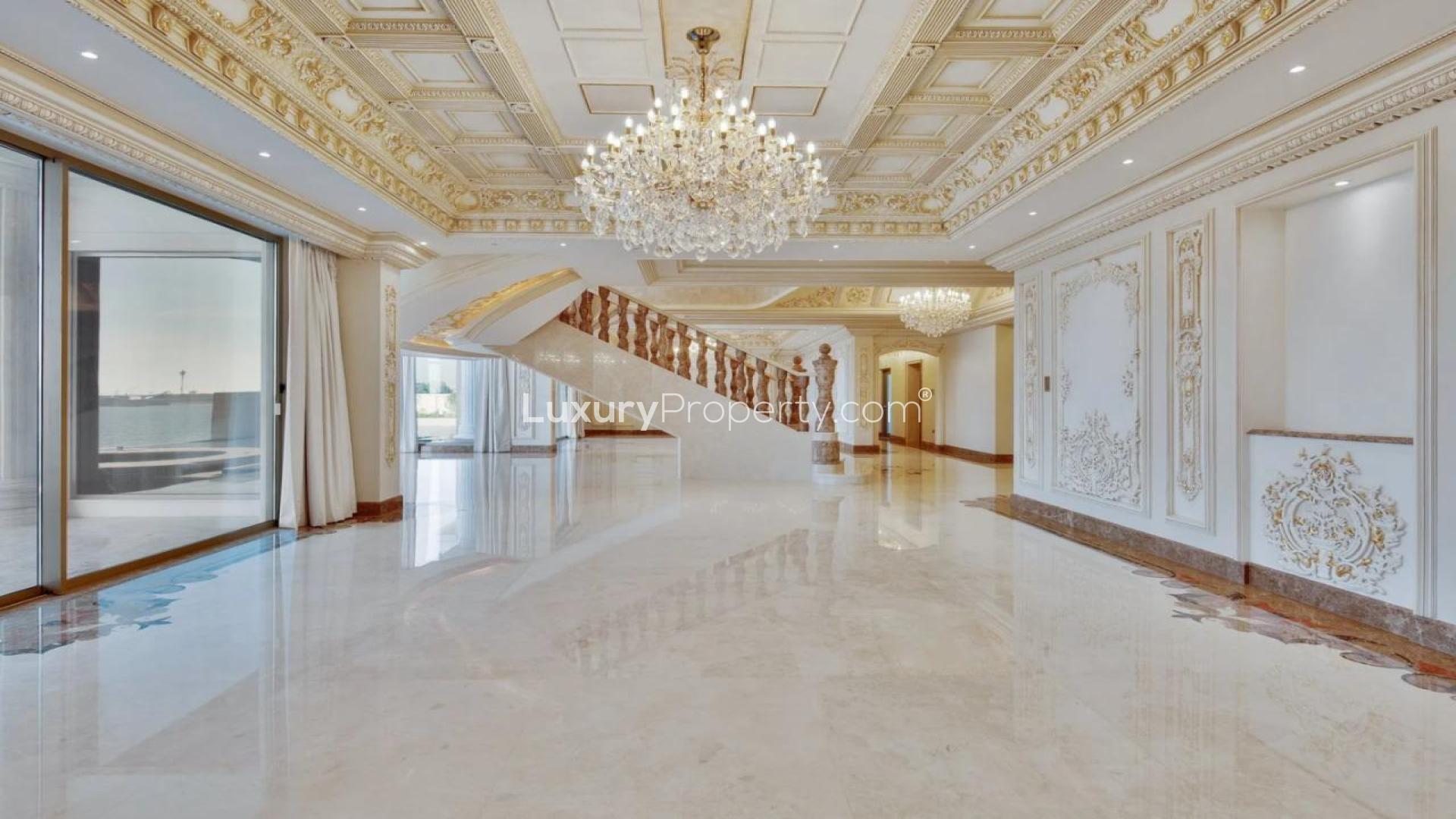 Luxurious Palm Jumeirah villa interior with ocean view, ornate ceilings, and chandeliers