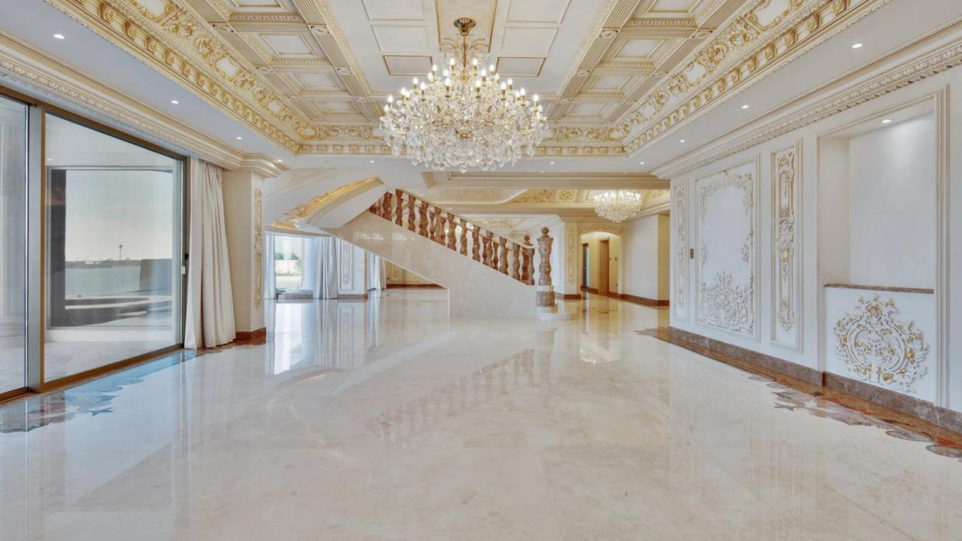 Luxurious Palm Jumeirah villa interior with ocean view, ornate ceilings, and chandeliers