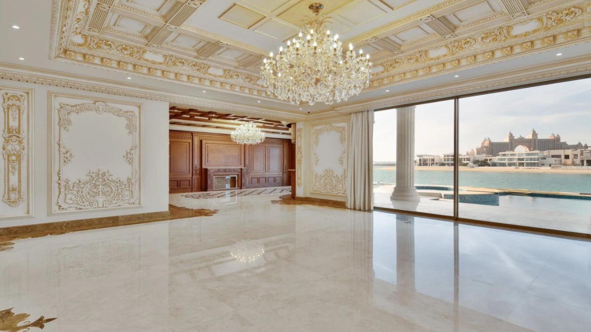 Luxurious grand staircase in Palm Jumeirah villa, featuring elegant chandeliers and sea views