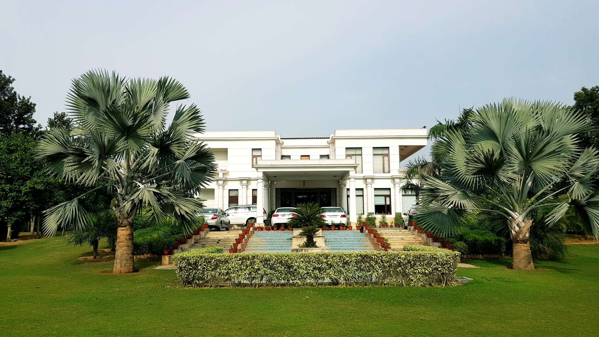 Exterior view of luxury villa with garden in Asola Farms, Delhi, for sale