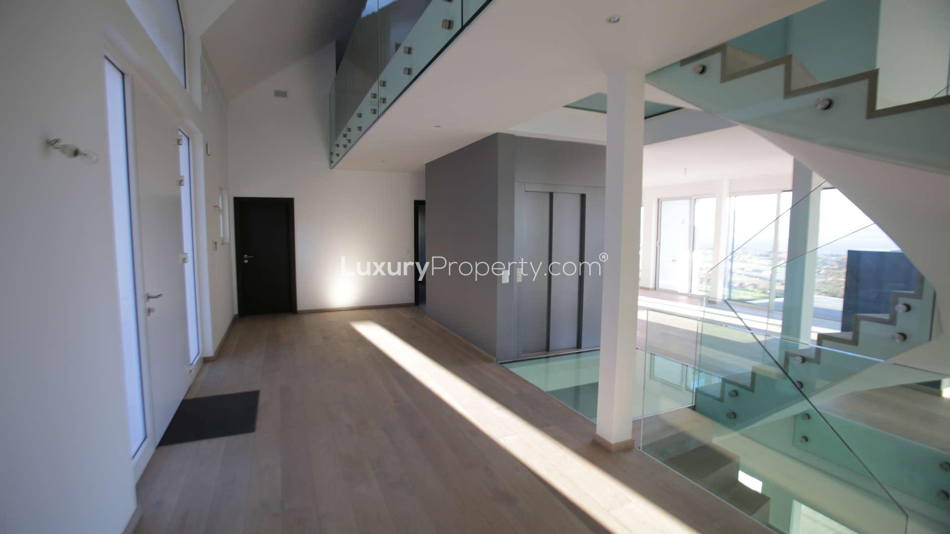 Modern kitchen with island and lake view in Bougy-Villars villa, Vaud, Switzerland