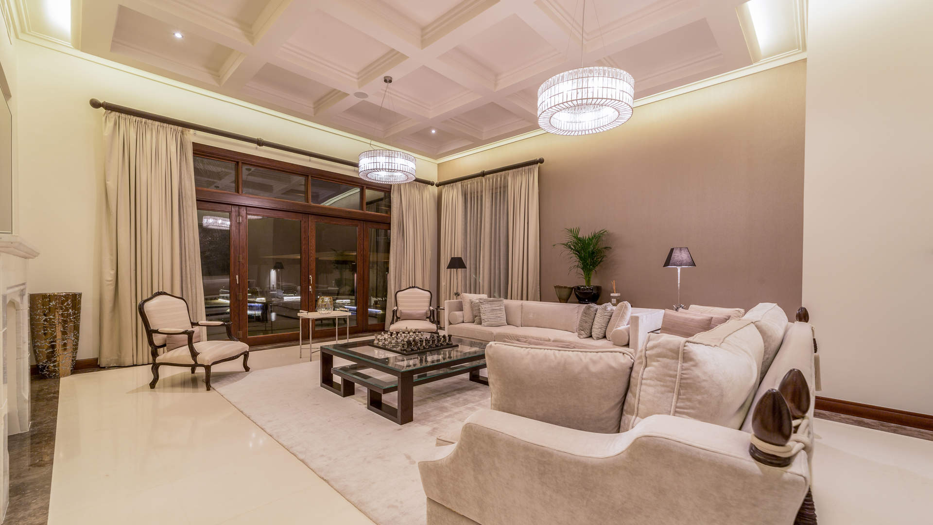 Luxurious Al Barari villa at night with pool and palm trees