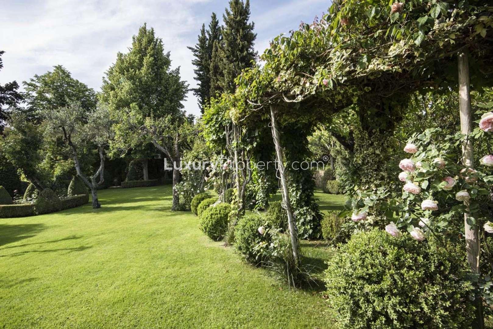 Lush garden view of elegant stone villa in Chianti, Florence, for sale