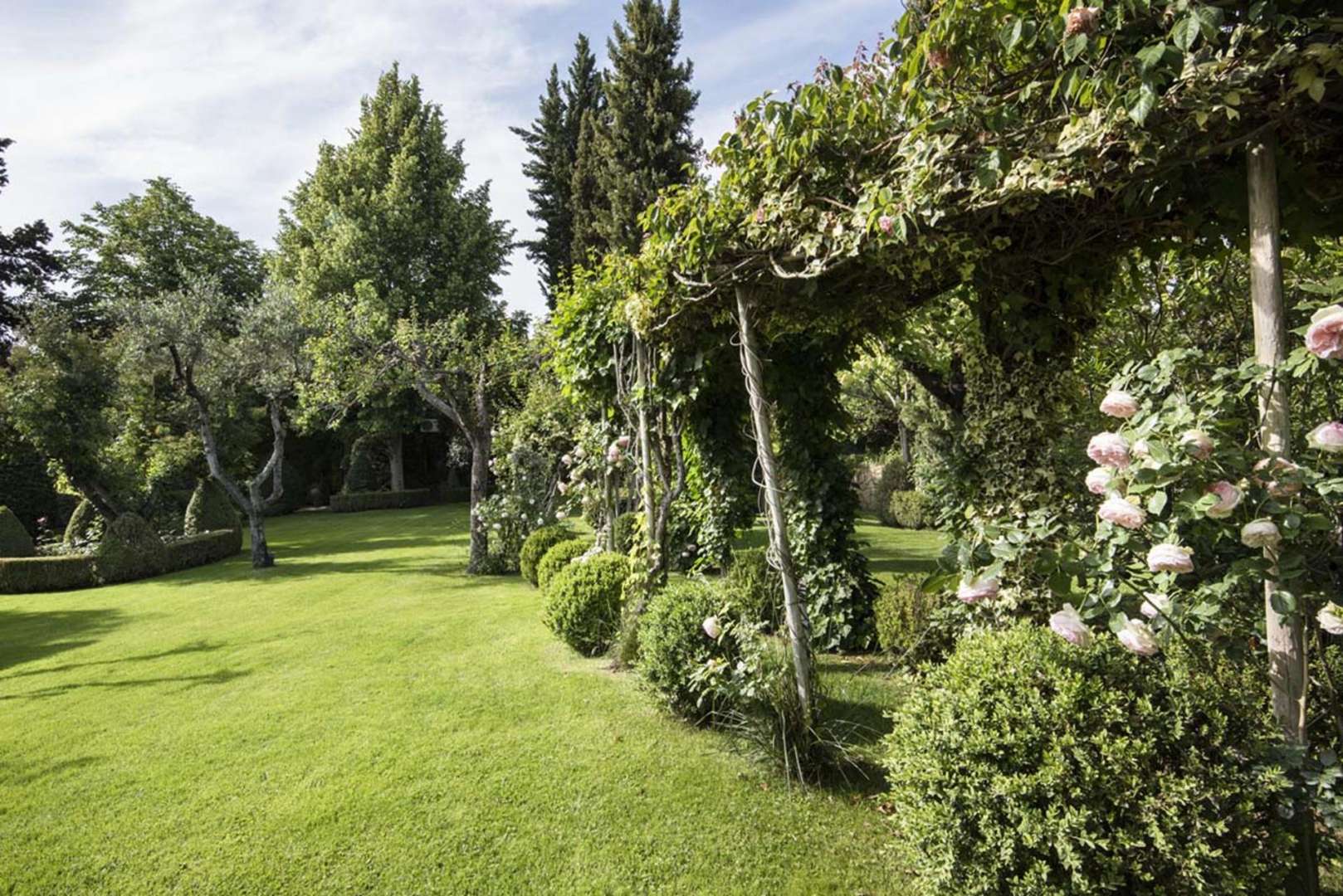Lush garden view of elegant stone villa in Chianti, Florence, for sale