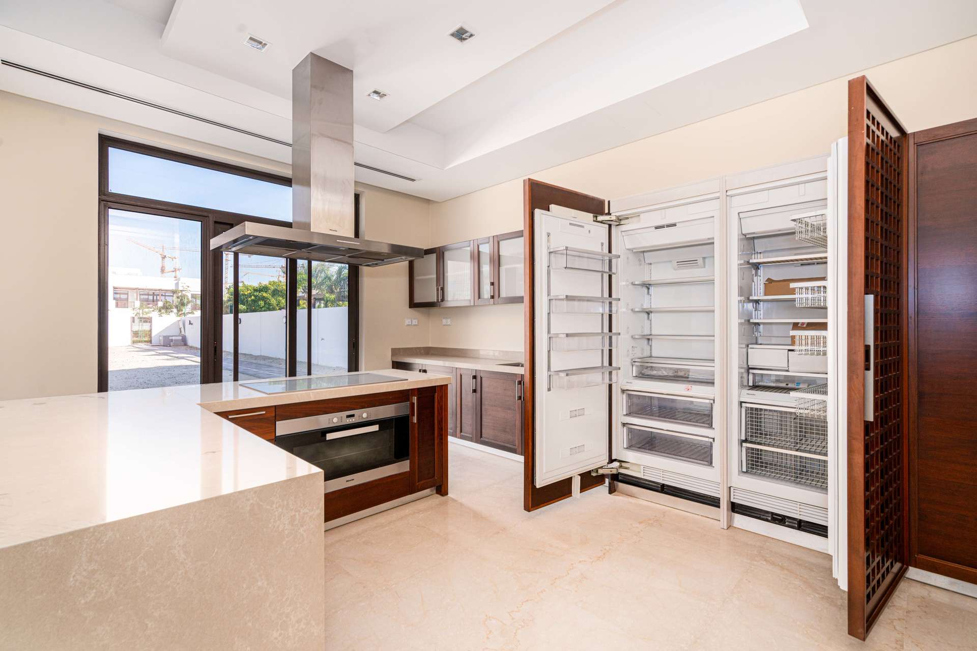 Modern open-plan living area in District One villa, featuring large windows and marble flooring