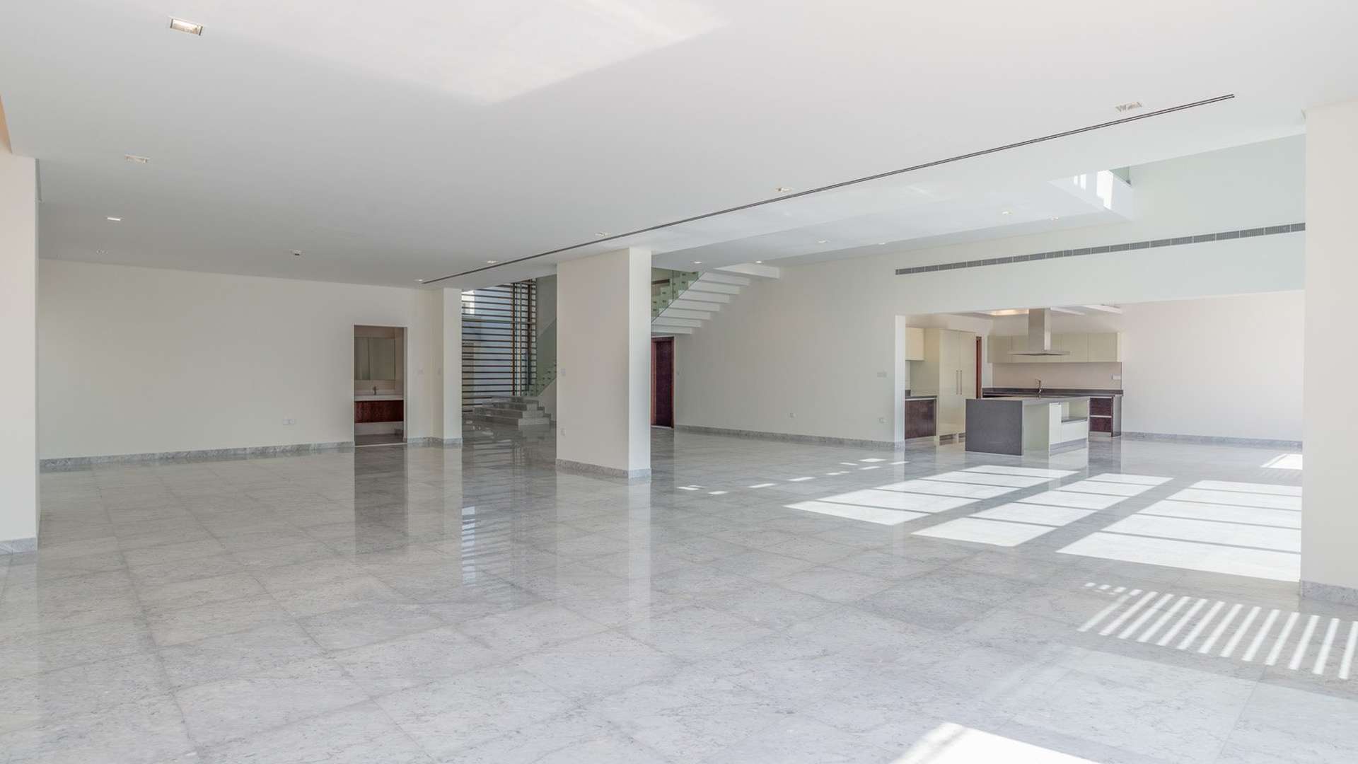Modern entryway of luxury villa in District One, Dubai, with glass staircase