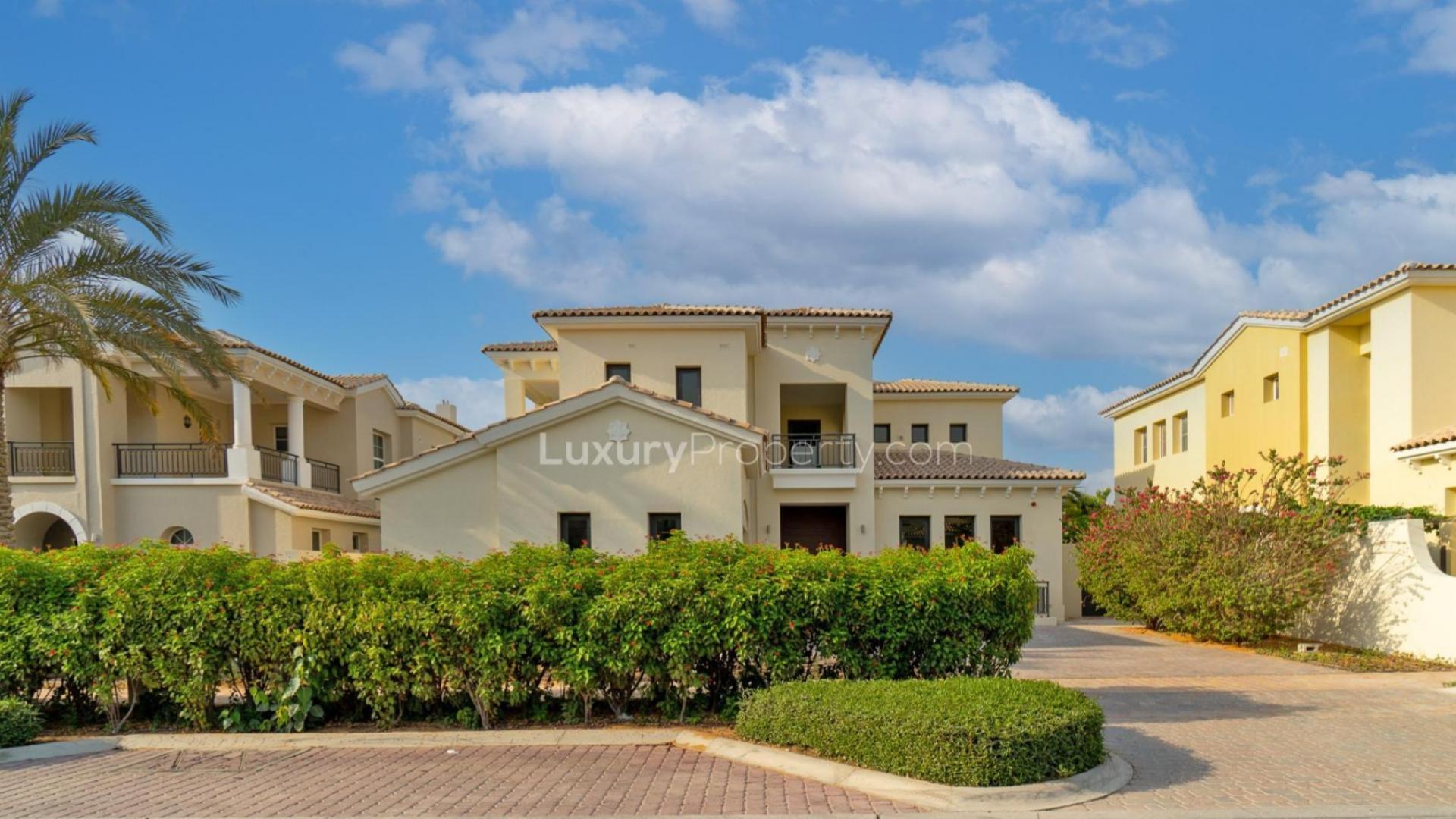 Alt text: "Luxury villa with private pool and golf course views in Jumeirah Golf Estates.","Stunning 6-bedroom villa exterior at Jumeirah Golf Estates, Earth community, for sale.",Outdoor seating area with fire pit in Jumeirah Golf Estates villa, Earth community