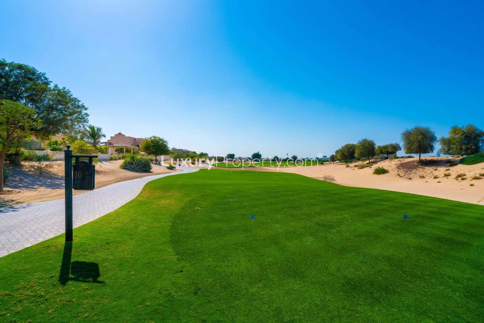 Bright living room with large arched window in Esmeralda villa, Victory Heights, Dubai