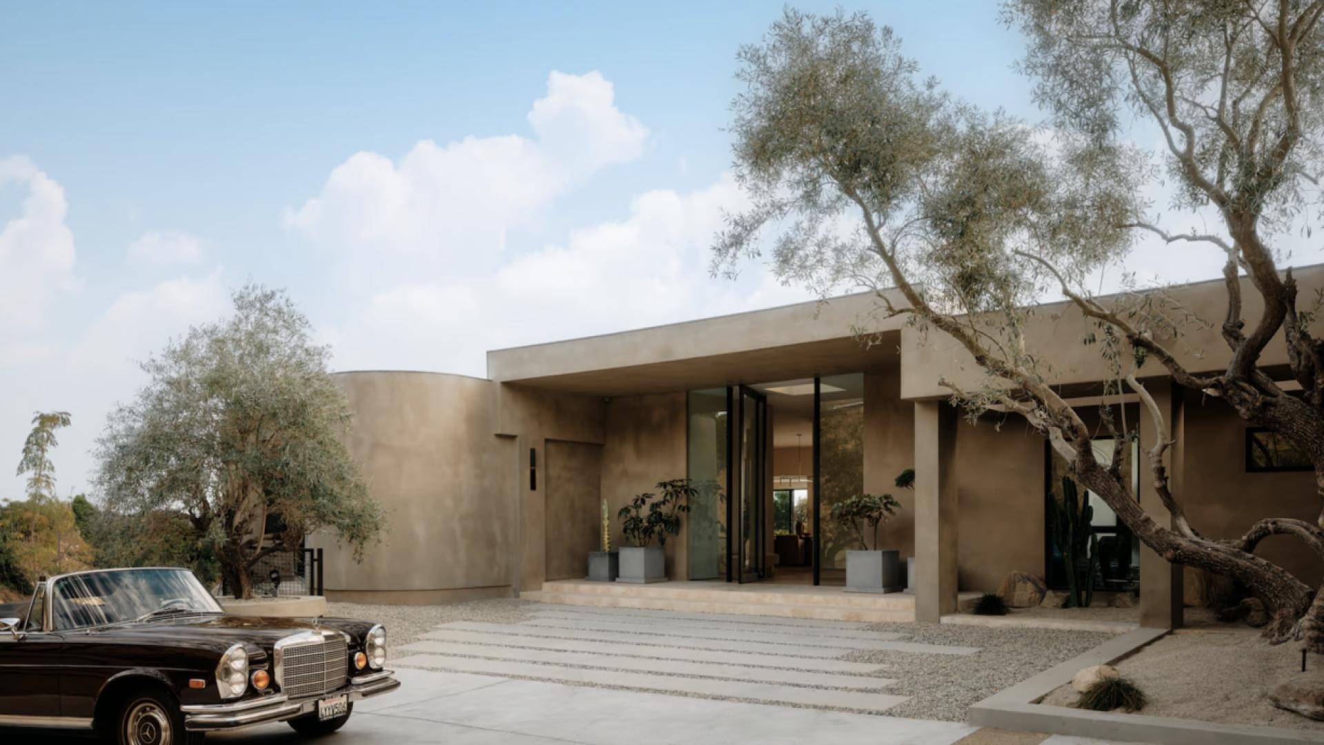 Organic modern villa exterior with pool, panoramic views in Beverly Hills, California at dusk