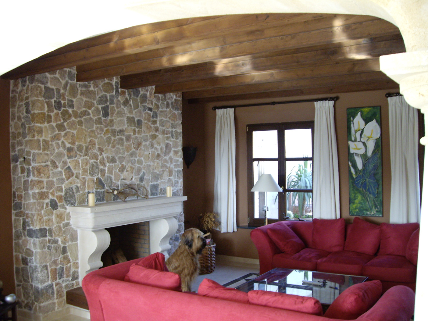 Interior of luxury villa in Puerto Andratx, Mallorca with stone fireplace and red sofas