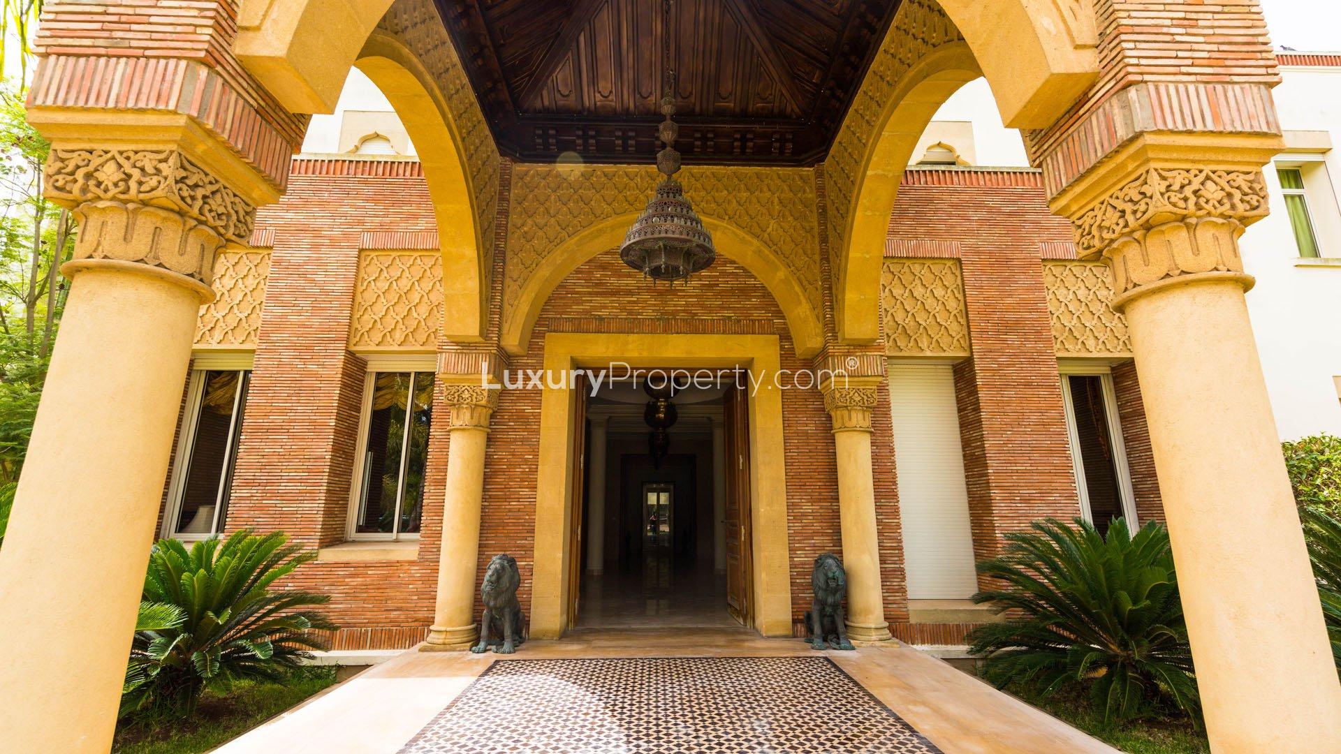 Elegant entrance of Villa Raga, Casablanca with lush gardens and intricate archway design