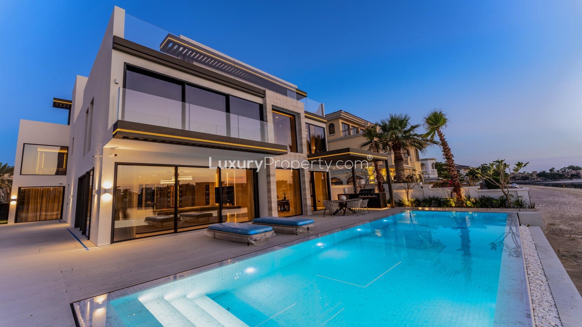 Luxurious Palm Jumeirah villa patio with pool and Atlantis views at sunset