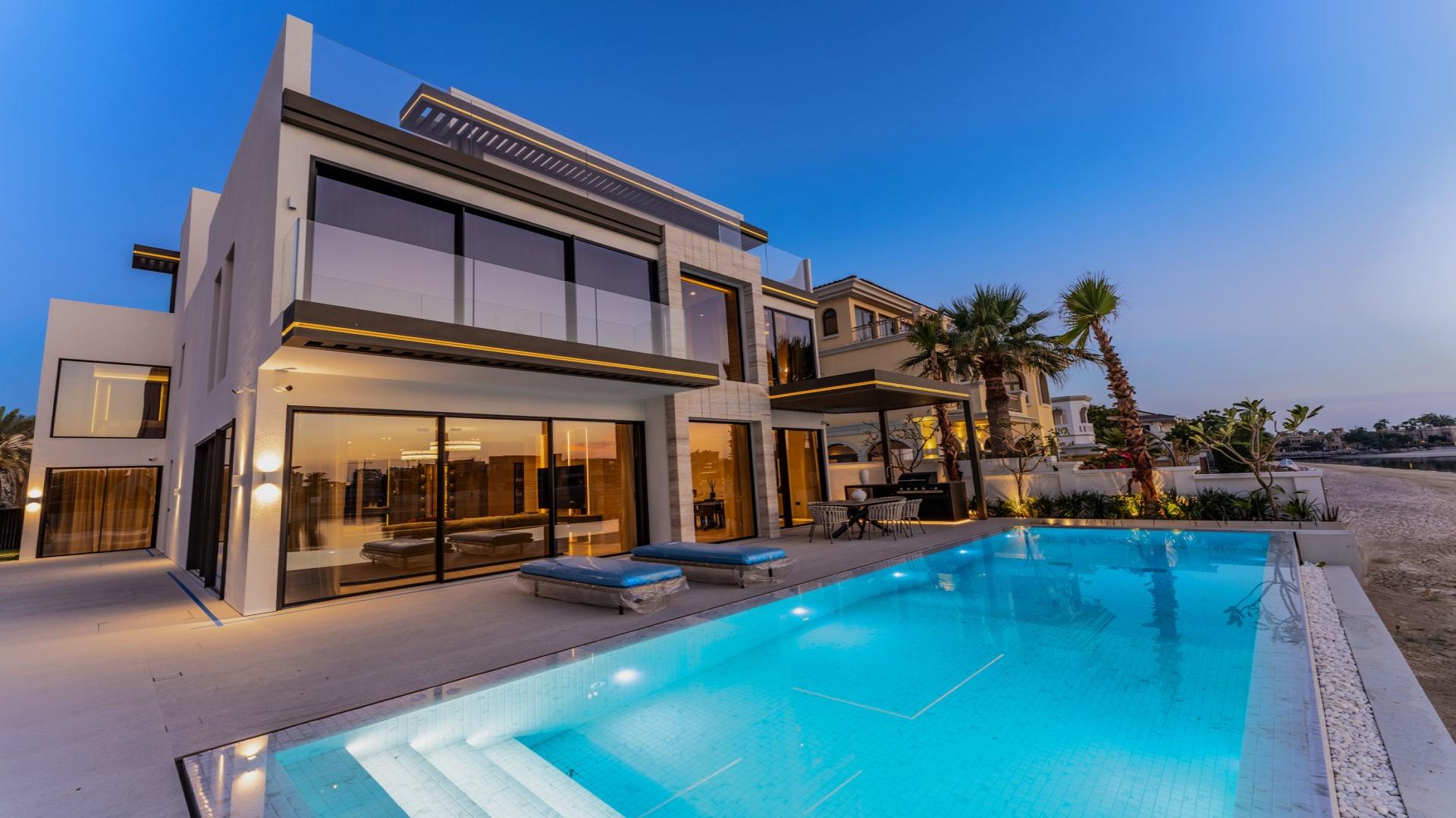 Luxurious Palm Jumeirah villa patio with pool and Atlantis views at sunset