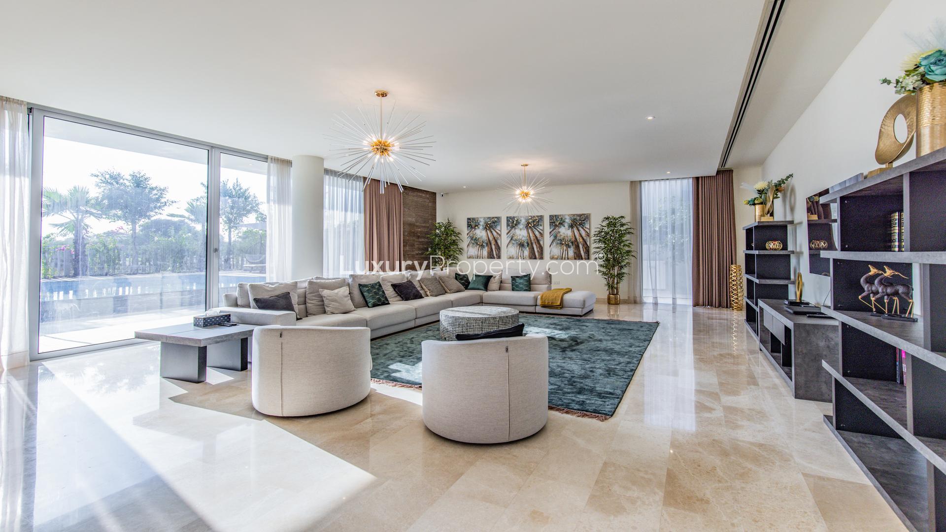 Luxurious living room in 6-bedroom villa, Dubai Hills, with modern decor and large windows