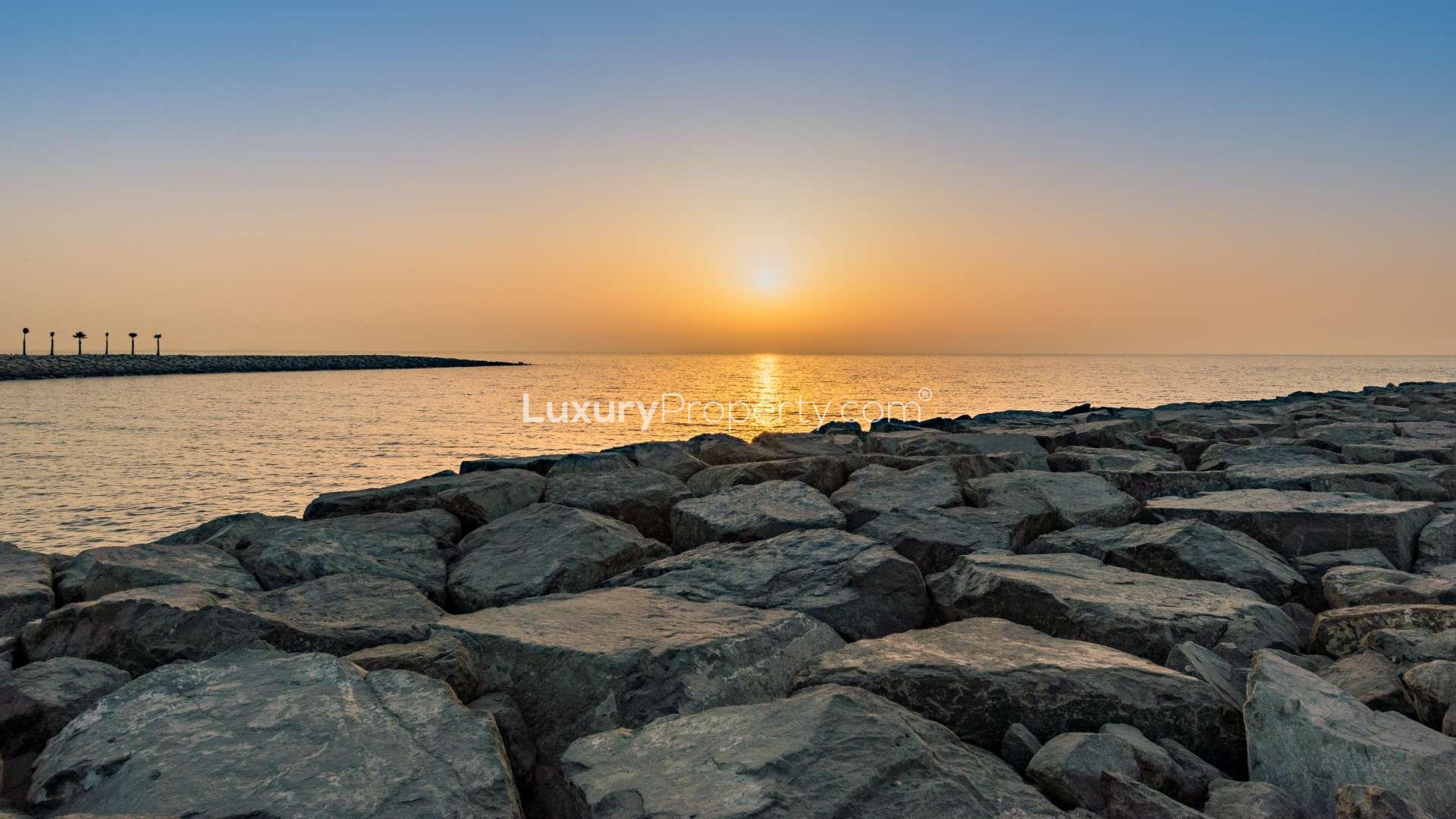 Sunset view over waterfront rocks at Pearl Jumeirah, near luxury villa for sale