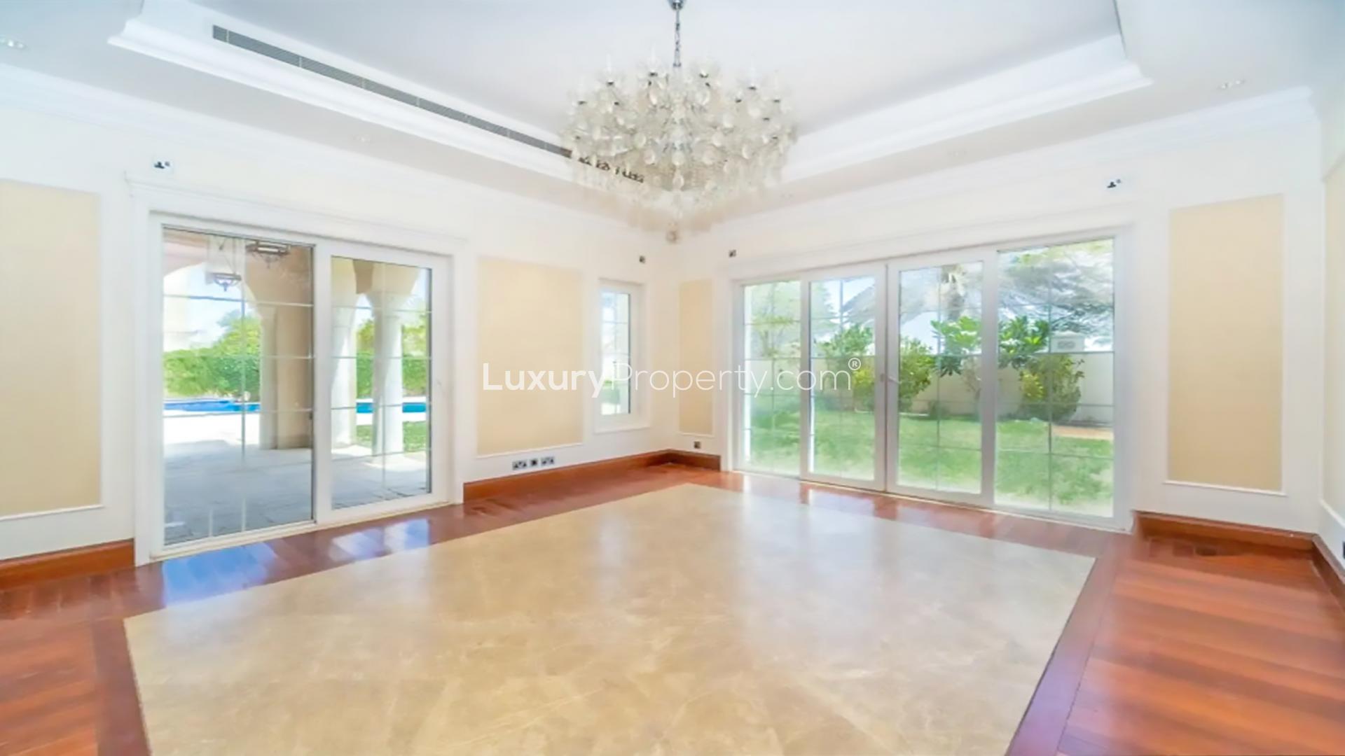 "Elegant villa courtyard in Polo Homes, Arabian Ranches with archways and potted plants.",Luxurious villa interior with chandelier, large windows, garden view in Polo Homes, Arabian Ranches