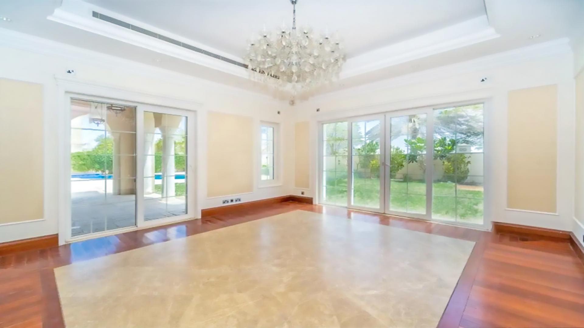 "Elegant villa courtyard in Polo Homes, Arabian Ranches with archways and potted plants.",Luxurious villa interior with chandelier, large windows, garden view in Polo Homes, Arabian Ranches