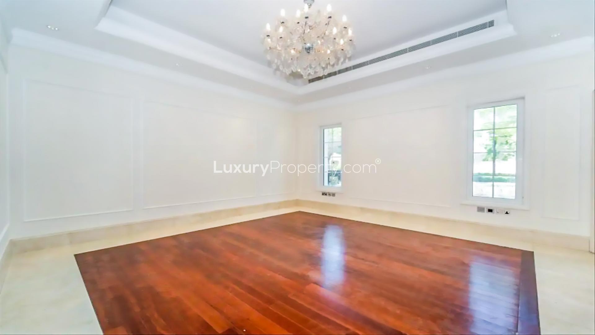 Empty room with wooden flooring and chandelier in Polo Homes villa, Arabian Ranches