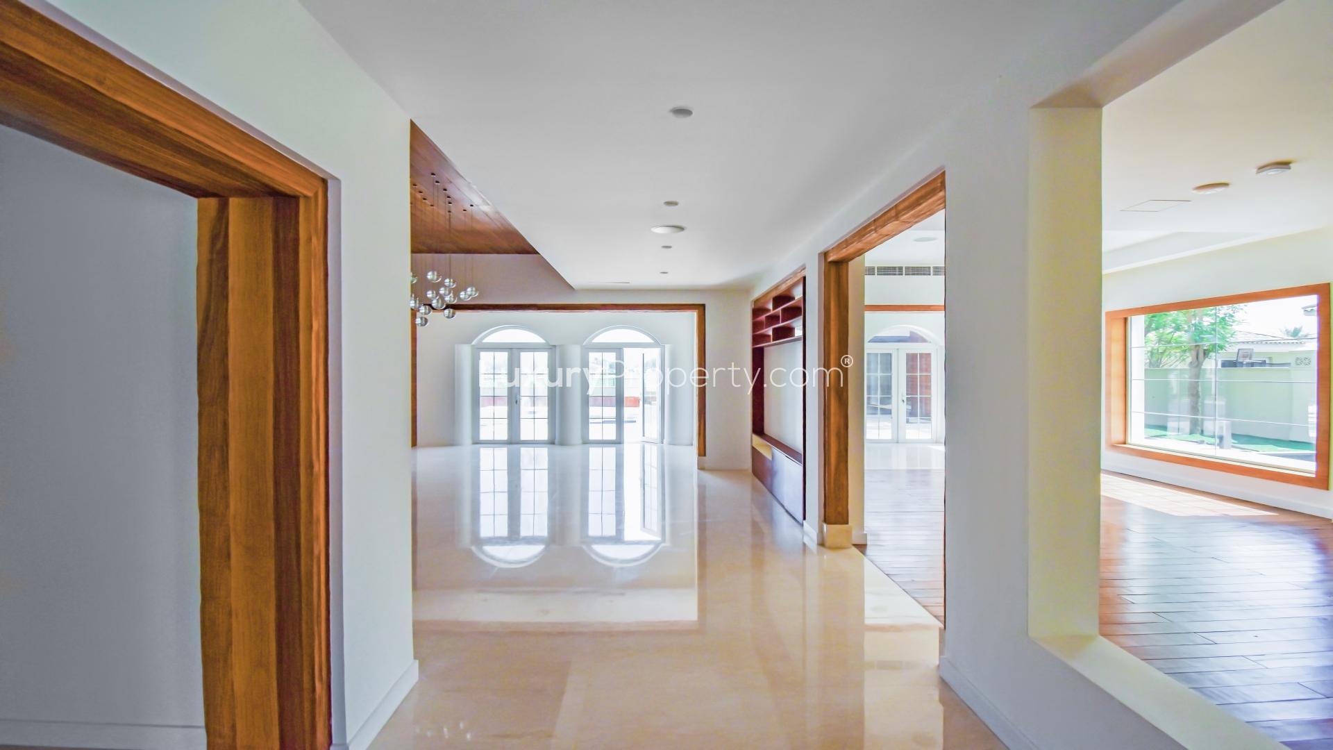 "Spacious living area in Polo Home Mansion, Arabian Ranches, with elegant wood flooring.",Spacious hallway in Arabian Ranches Polo Home Mansion with elegant flooring and large windows