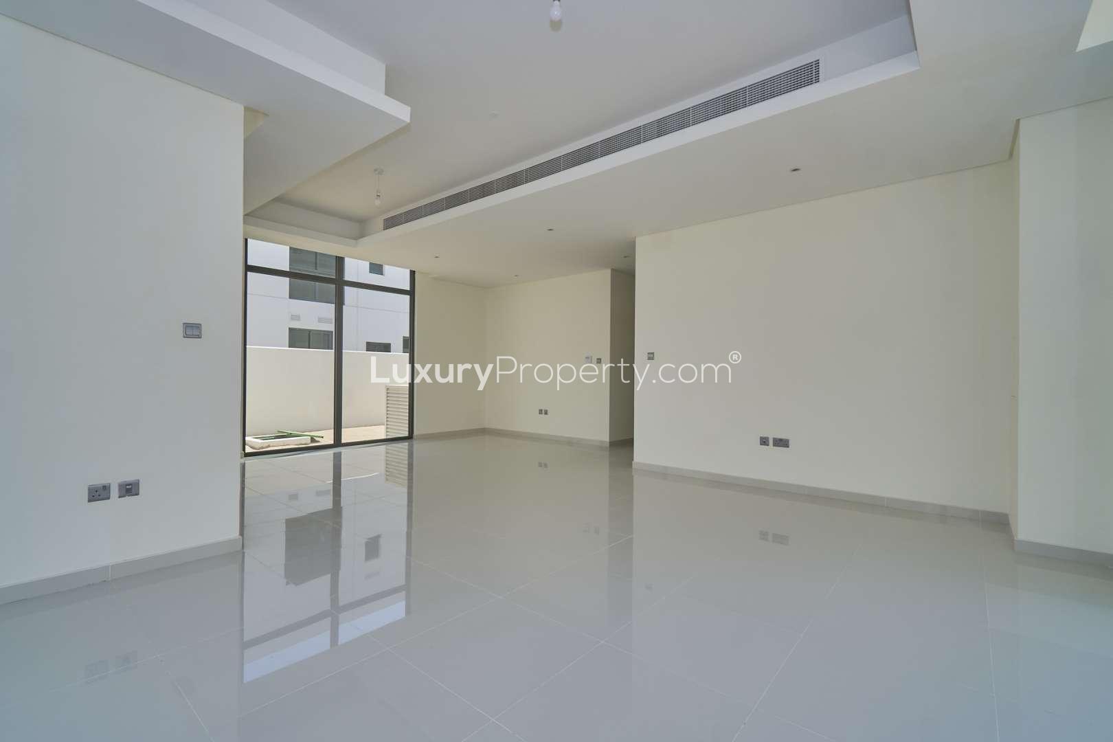 Spacious living room in 6-bedroom villa, Primrose, Damac Hills 2, large windows, bright interior