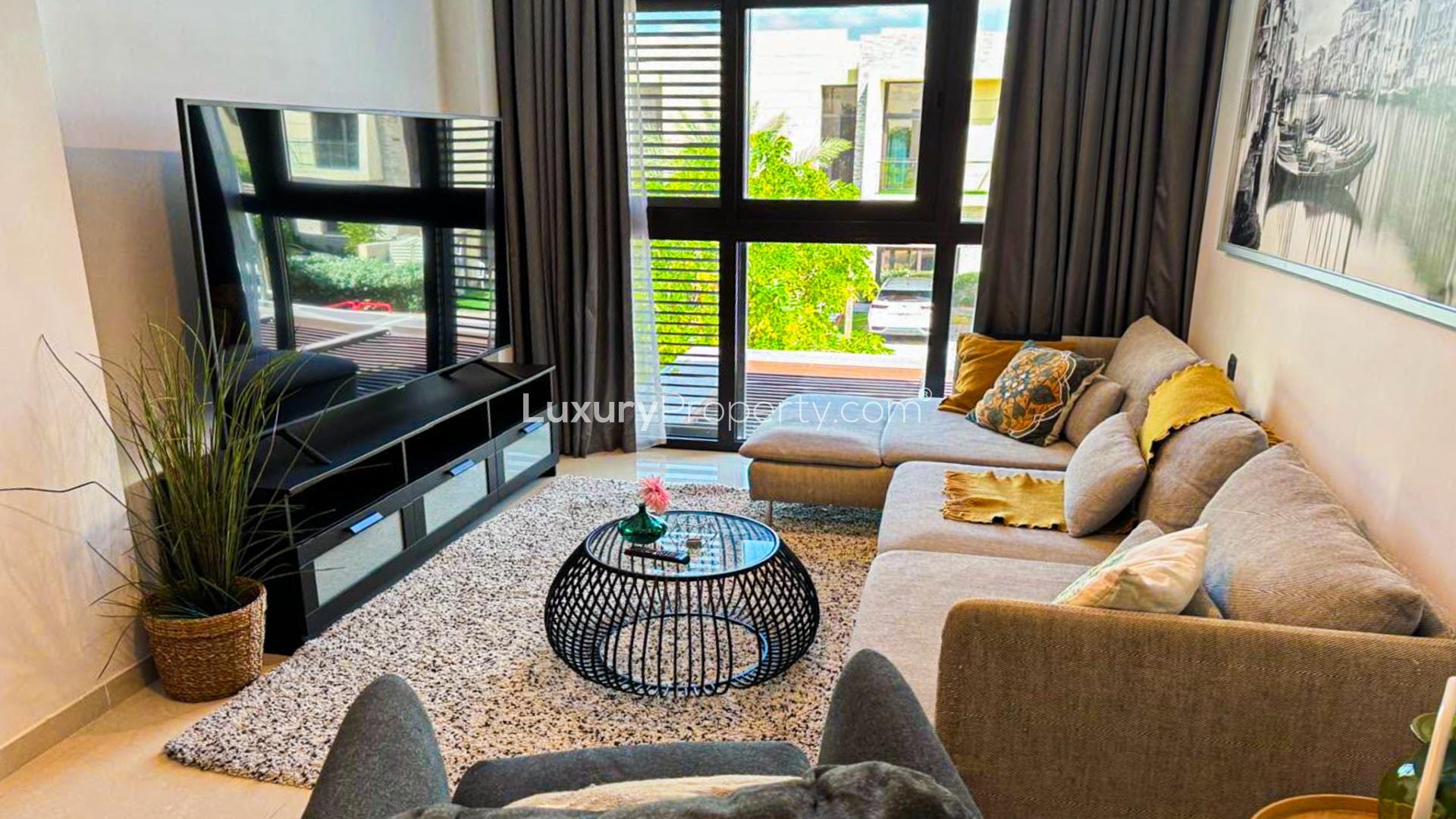 Modern living room in Damac Hills villa, featuring stylish decor and large windows