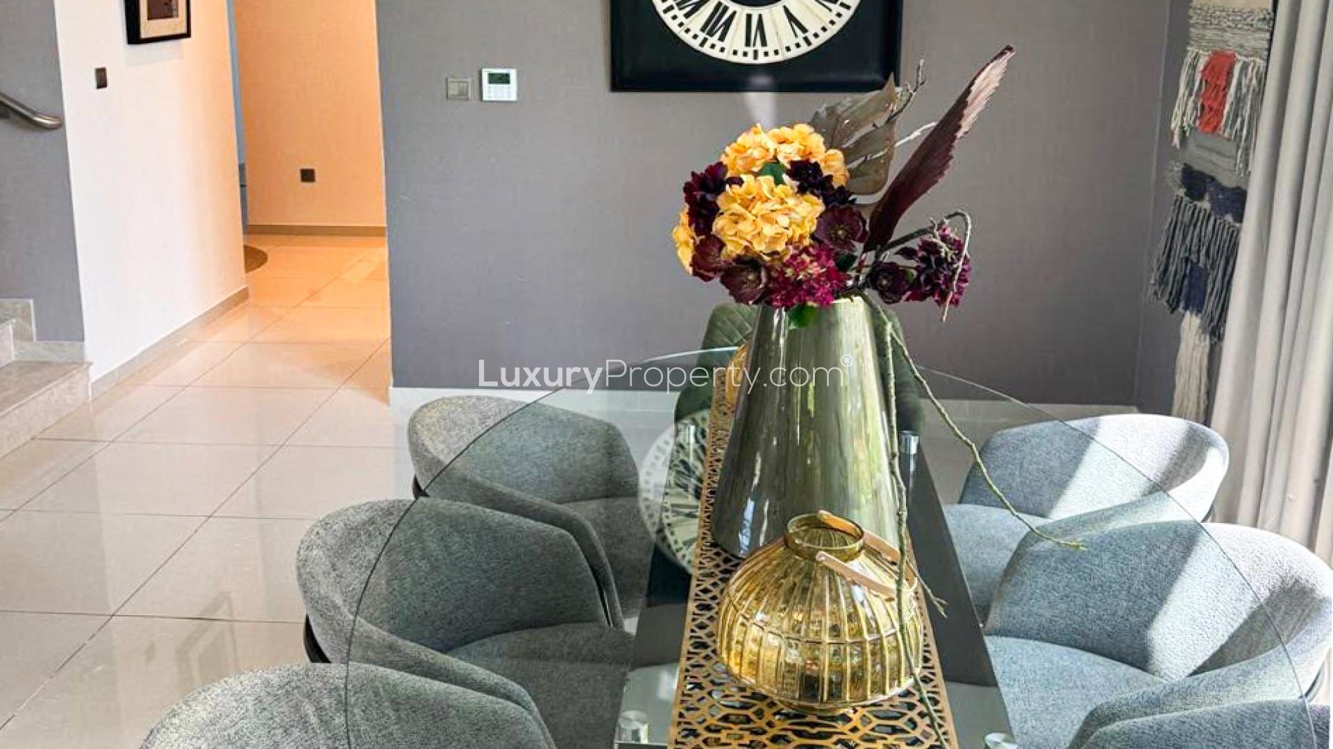 Luxurious living room in Damac Hills villa, featuring elegant leather furniture and garden views