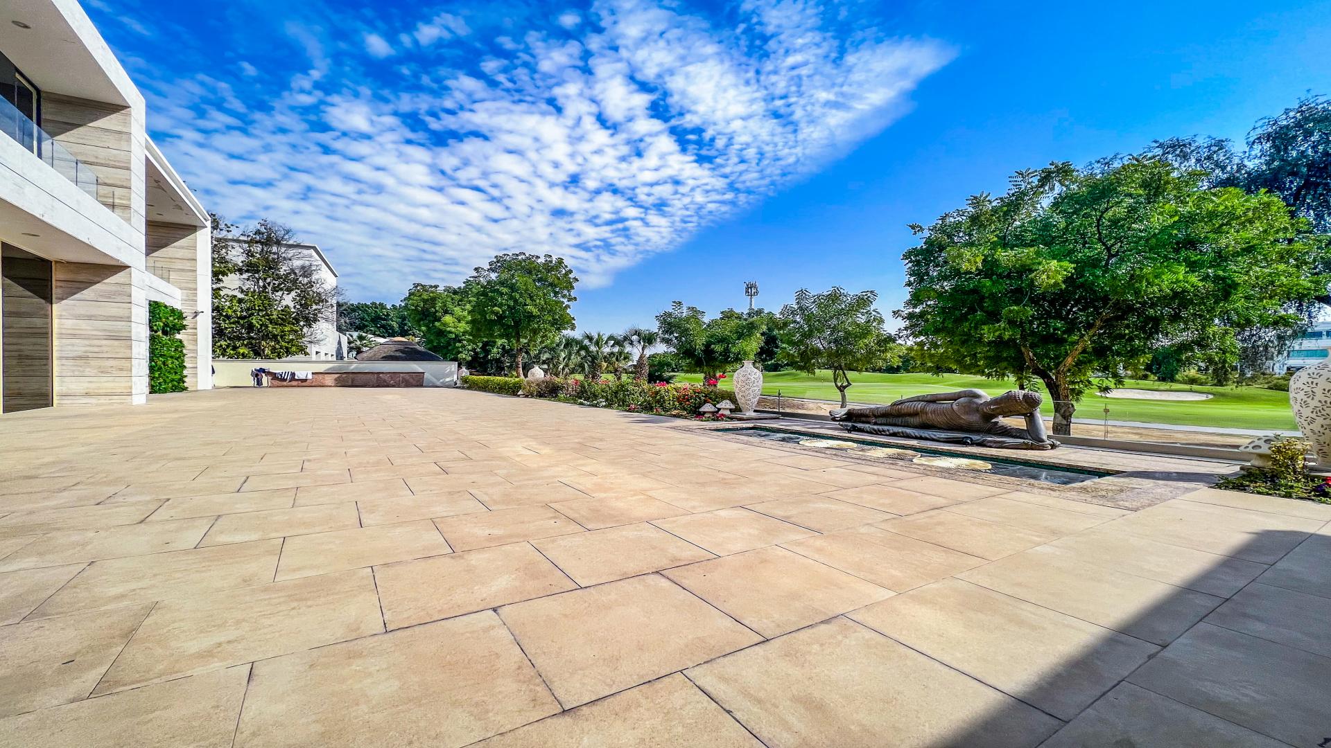 Custom-built 6-bedroom villa exterior in lush garden, Emirates Hills, Sector H