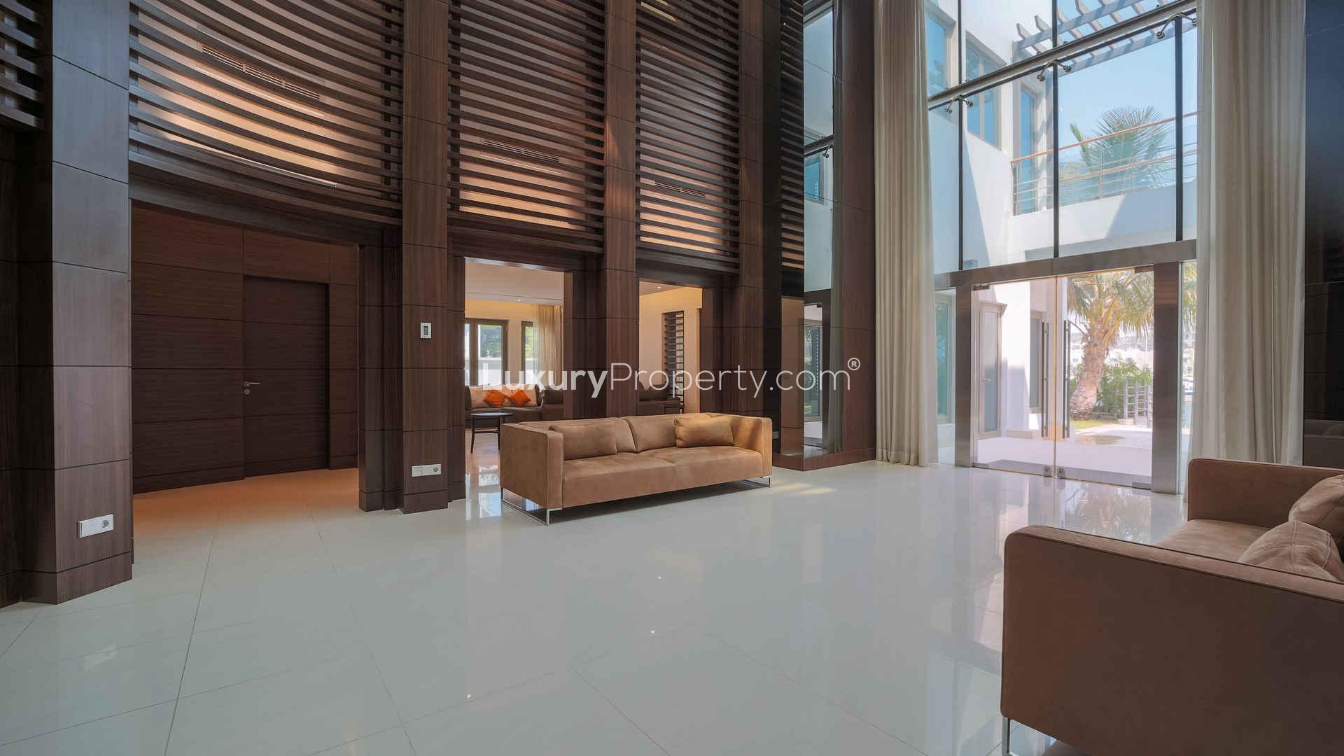 Modern living area in upgraded 6-bed Palm Jumeirah villa with stylish wood paneling