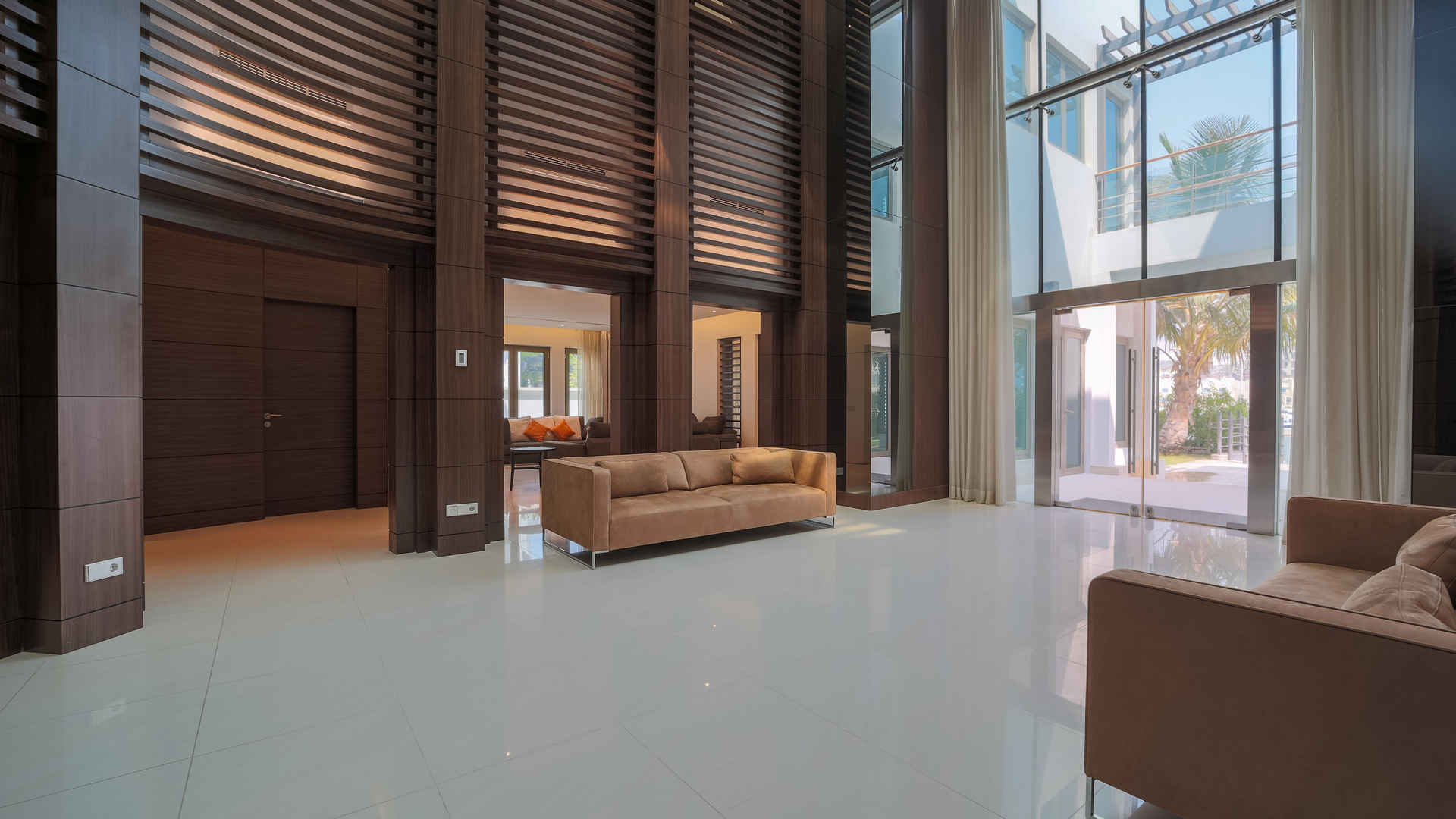 Modern living area in upgraded 6-bed Palm Jumeirah villa with stylish wood paneling