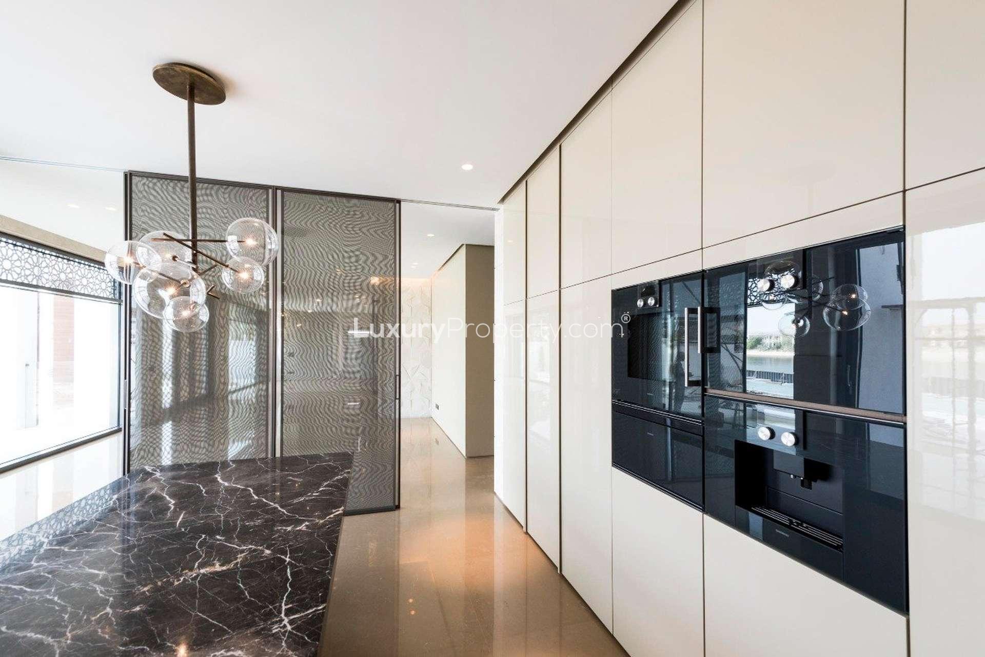 Modern kitchen in six-bedroom Palm Jumeirah villa with marble island and stylish lighting