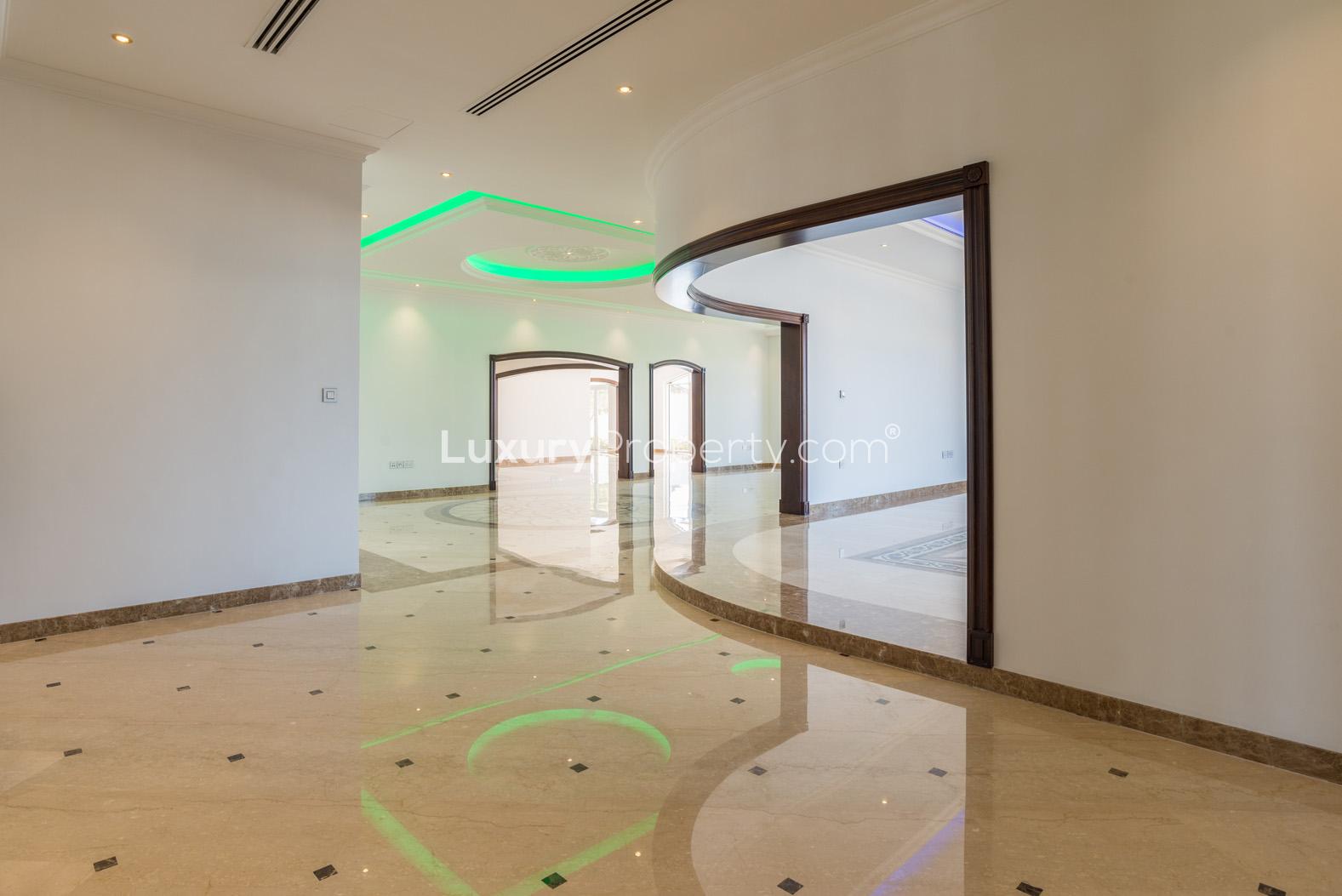 Empty living room in Palm Jumeirah villa with large windows and garden view