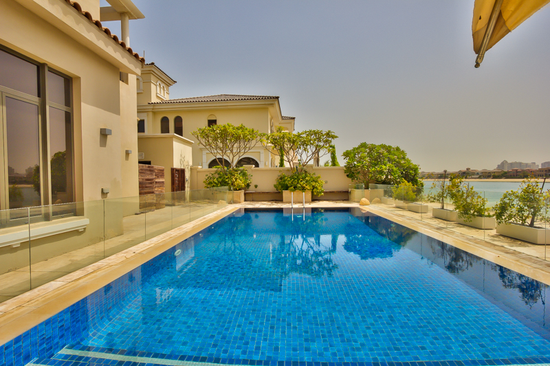 Modern kitchen in 6-bedroom Palm Jumeirah villa, featuring sleek cabinets and wooden island