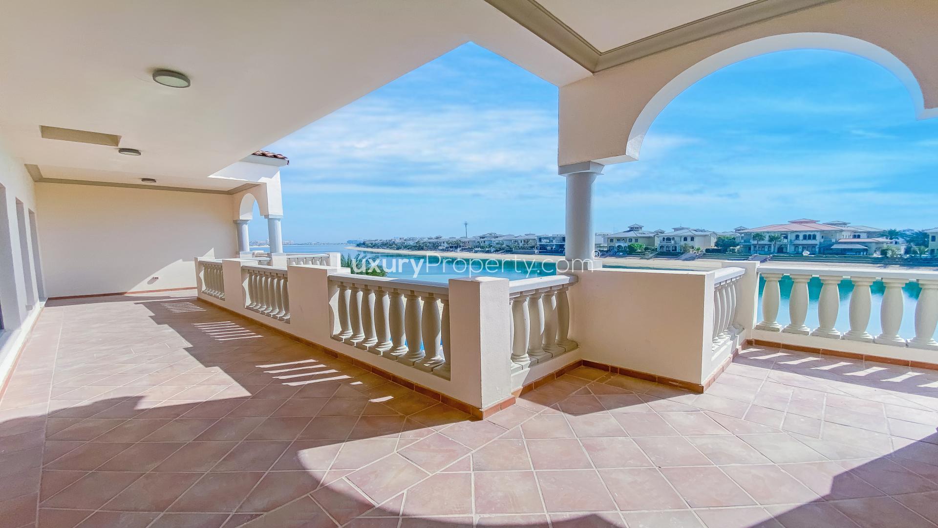 "Spacious Palm Jumeirah villa patio with pool, lush lawn, and waterfront views for sale.",Spacious terrace with sea view at renovated 6-bedroom villa, Palm Jumeirah Signature Villas