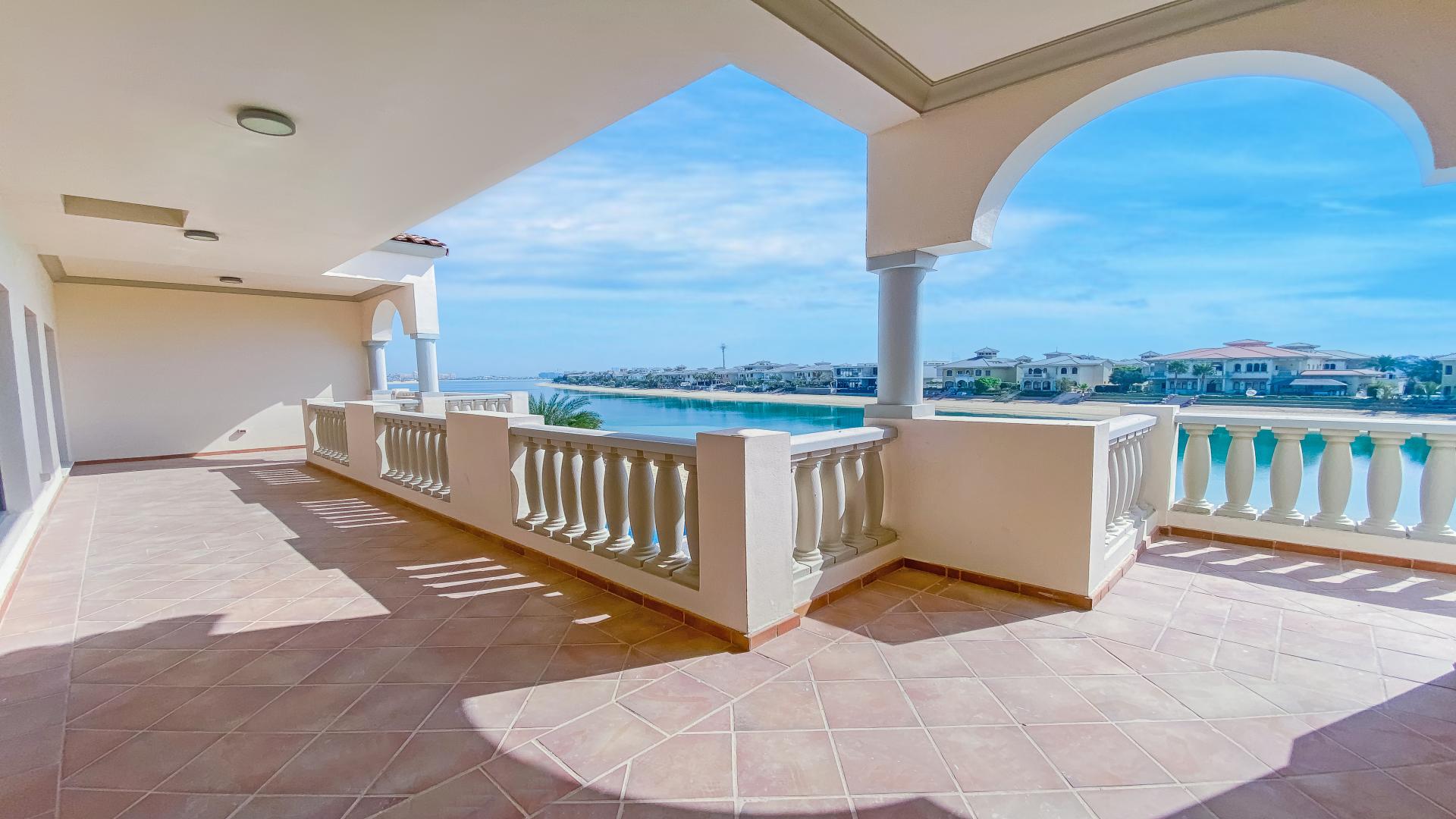 "Spacious Palm Jumeirah villa patio with pool, lush lawn, and waterfront views for sale.",Spacious terrace with sea view at renovated 6-bedroom villa, Palm Jumeirah Signature Villas