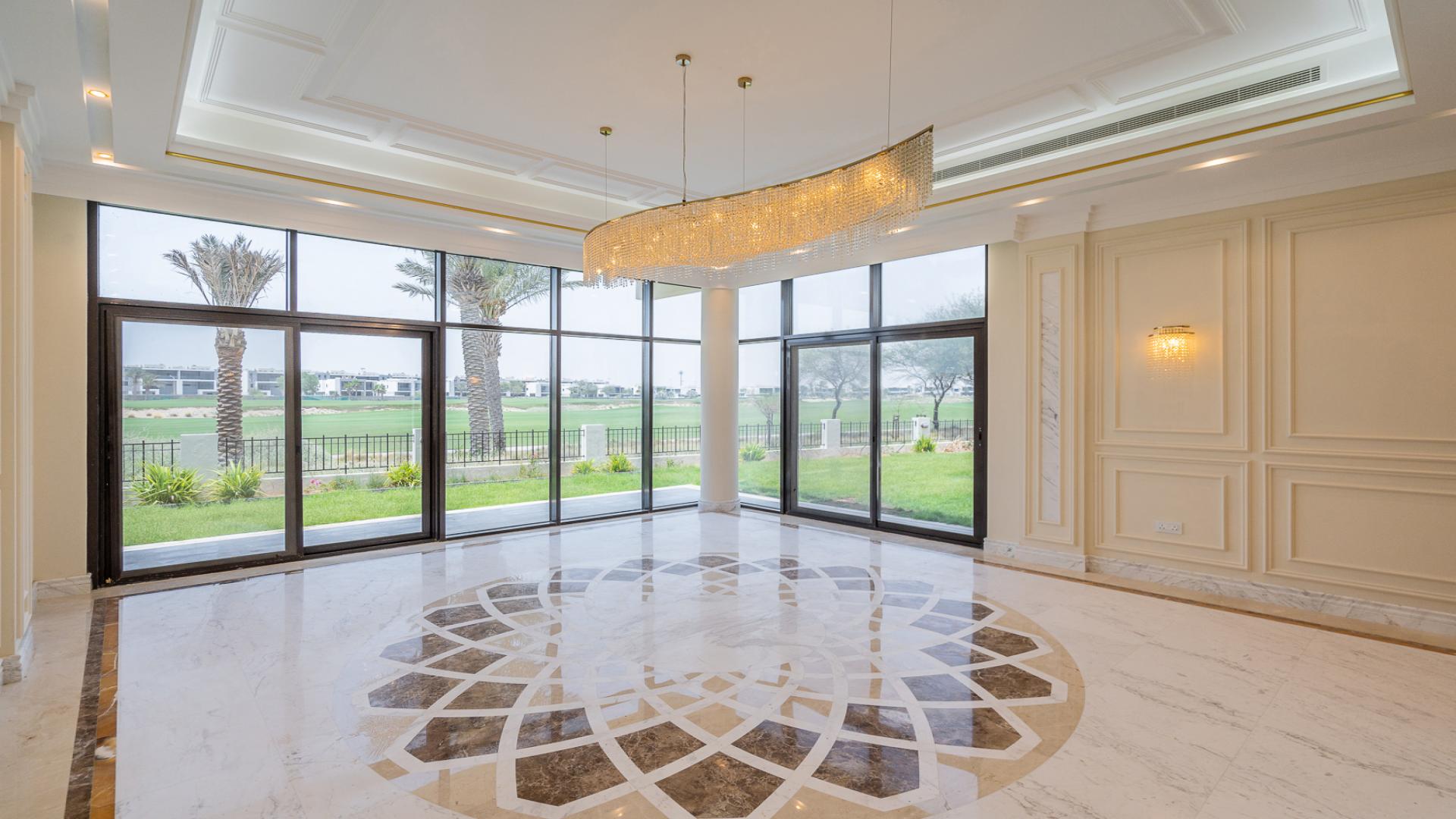 Single row villa patio with lush lawn and golf course view in Damac Hills