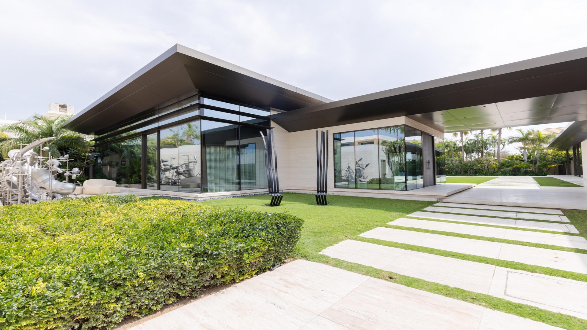 Contemporary villa in Umm Suqeim 1, Dubai with illuminated pool and garden oasis