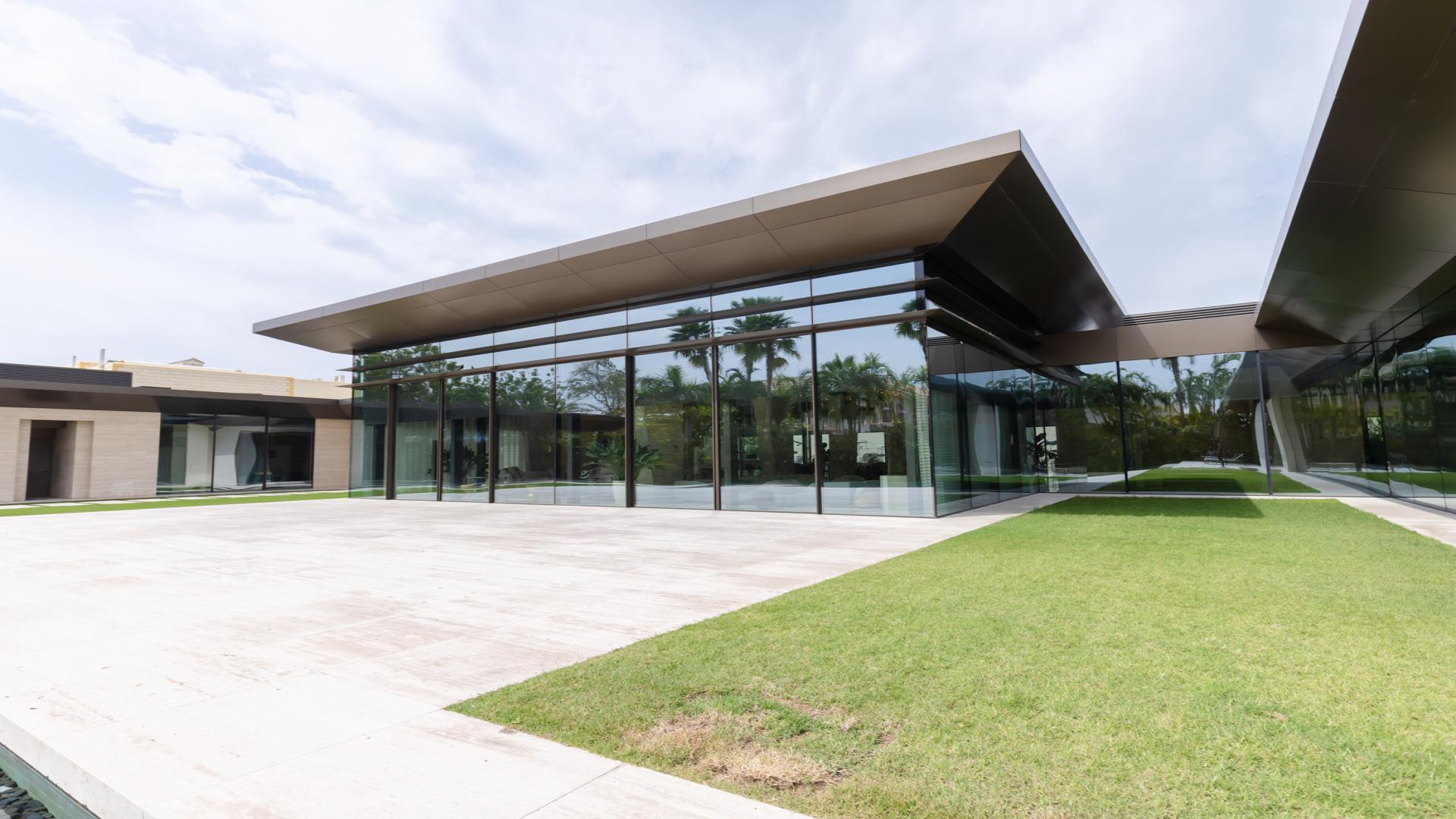 Modern villa exterior with glass facade and garden in Umm Suqeim 1, Dubai