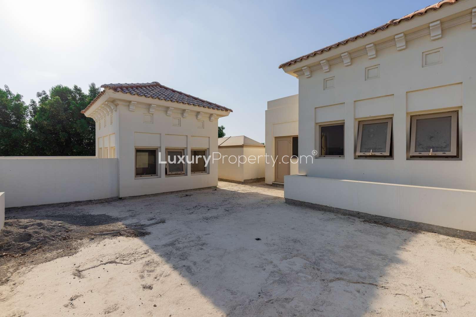 Al Barari villa with lake view, lush greenery, and modern architecture in The Reserve