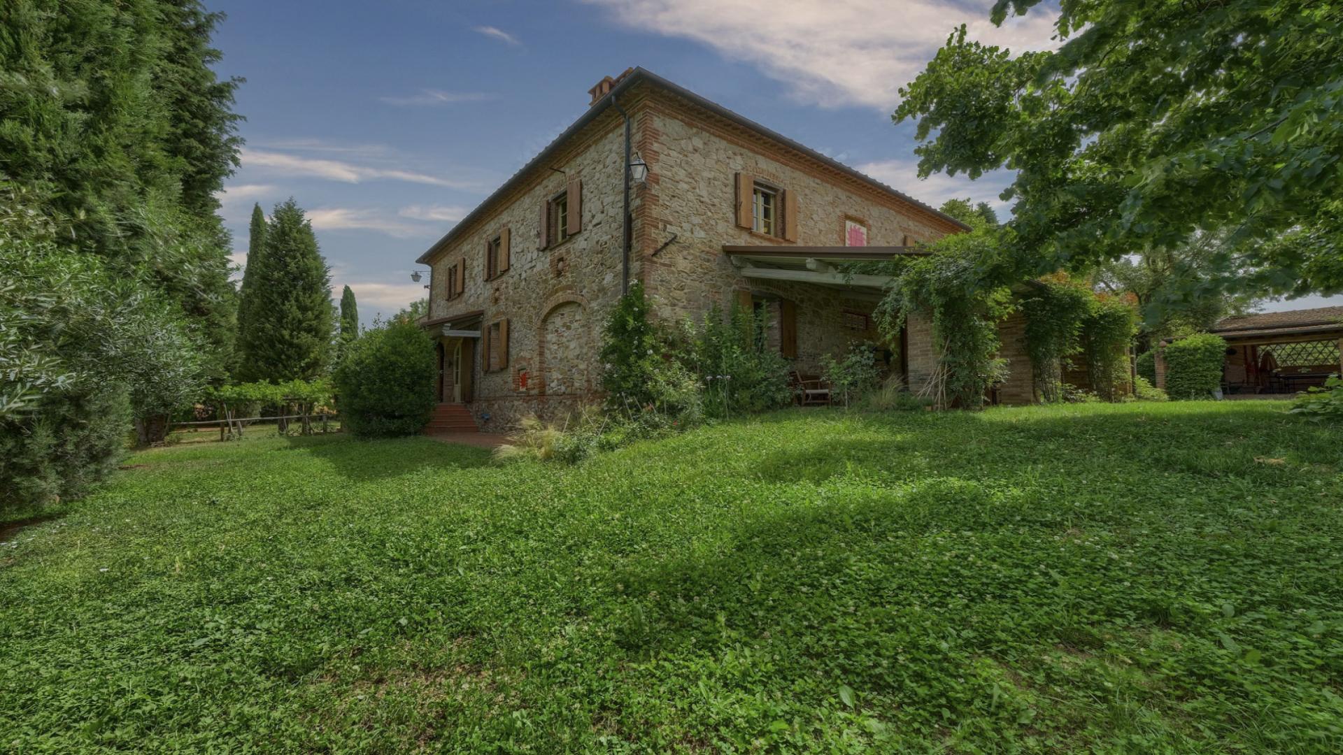 Villa Casa Del Sole Arezzo courtyard with lush greenery and rustic stone exterior